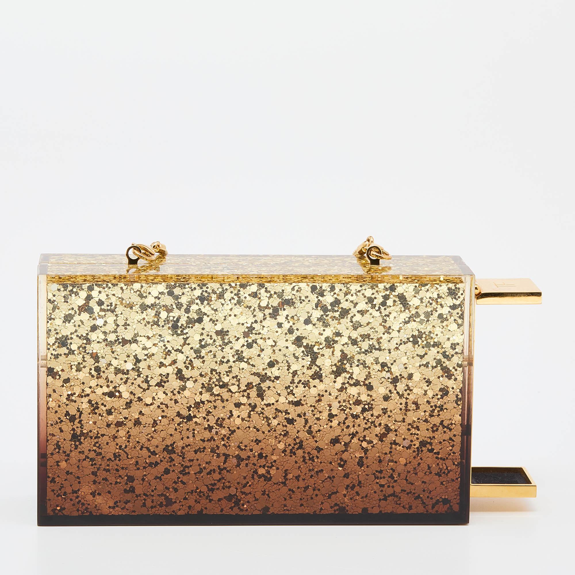 Carry this metallic gold beauty in style. Coming from Tom Ford, this stunning clutch is made from plexiglass and is equipped with a sizeable interior. The structured, artistic clutch features an ombre effect and a slender, gold-tone shoulder strap.

