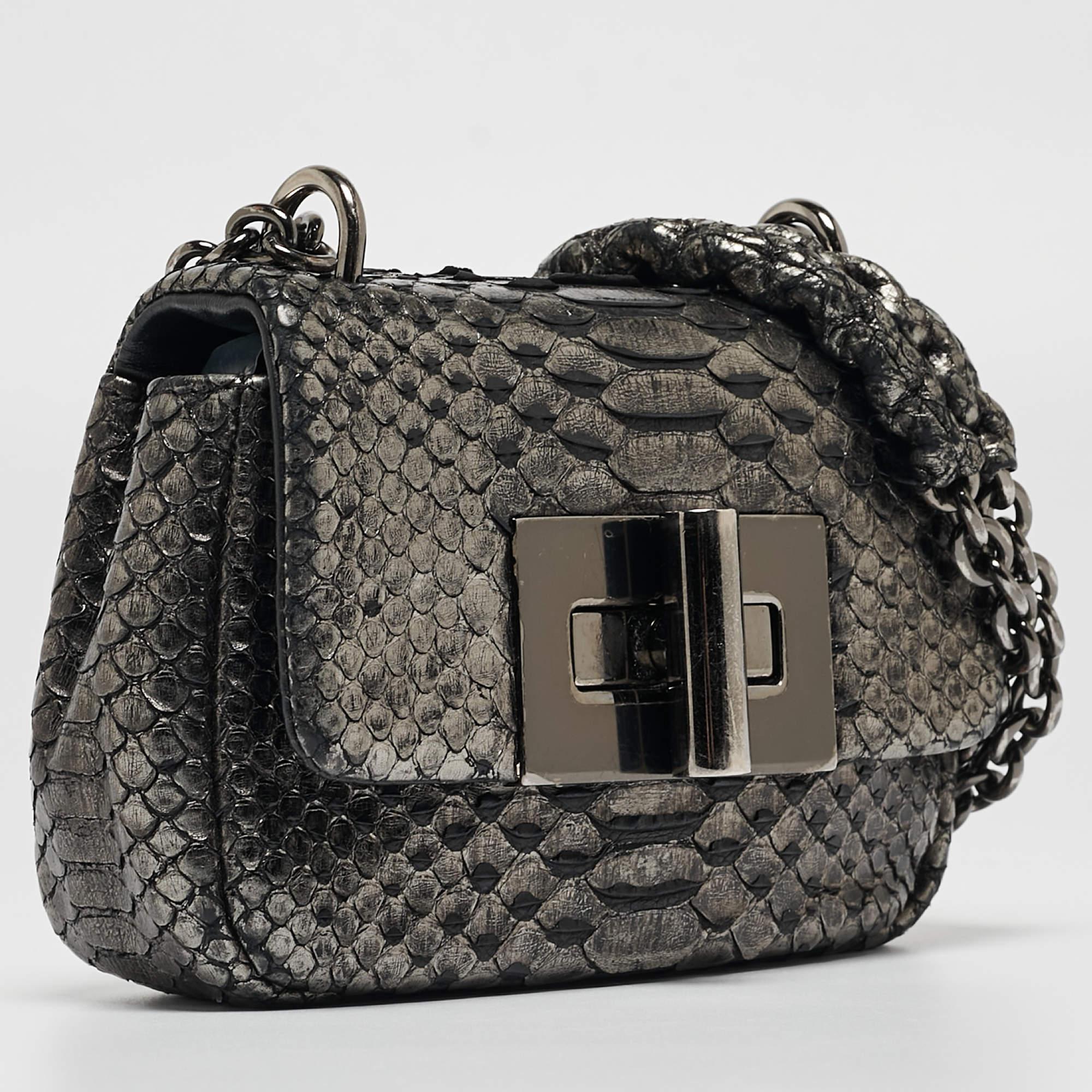 This gorgeous mini Natalia shoulder bag comes from the House of Tom Ford. It is crafted from python skin, with a large lock closure perched on the front. It features chain handles, black-toned hardware, and a leather-lined interior. Spacious,