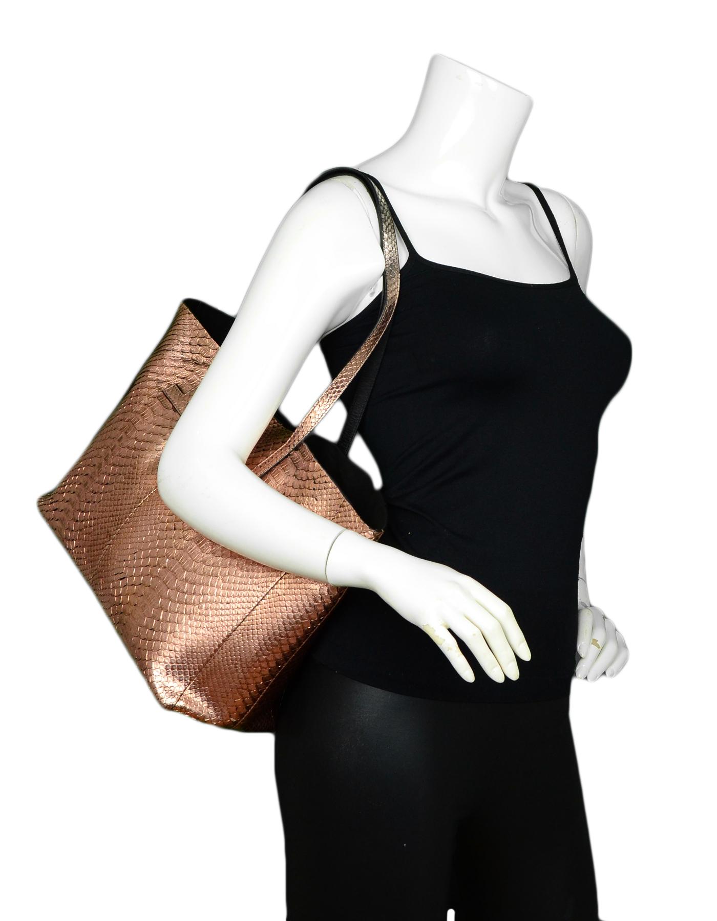 Tom Ford Rose Gold Python Small T Tote Bag

Made In: Italy
Color: Gold
Hardware: Silvertone 
Materials: Python, Rosegold
Lining: Suede
Closure/Opening: Open top
Exterior Pockets: None
Interior Pockets: One zip pocket
Exterior Condition: Excellent
