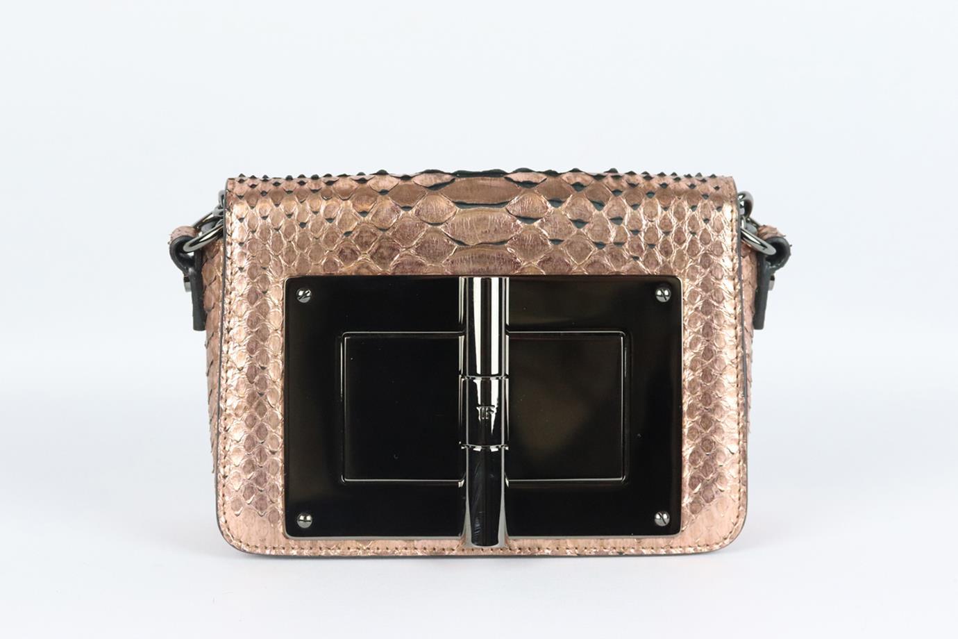 Tom Ford Natalia small metallic python shoulder bag. Made from rose-gold pythons with the brand’s signature gunmetal-tone bar on the front. Rose-gold python. Twist lock fastening at the front. Does not come with dustbag or box. Width: 7 in. Height: