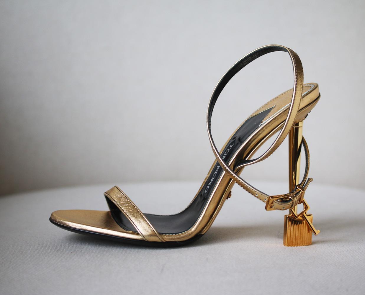 TOM FORD's sand leather sandals are set on a gleaming metallic heel and finished with the label's signature 'Padlock' and key. Heel measures approximately 105mm/ 4 inches. Metallic-gold leather (Calf). Buckle-fastening ankle strap. Designer colour: