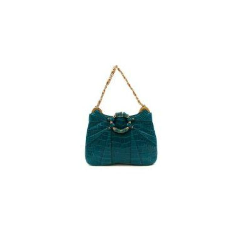 Gucci Tom Ford petrol blue crocodile bag
 
 - Part of Tom Ford's final Gucci collection, FW04
 - Petrol blue crocodile hide, with crystal and gold-tone metal accents in the shape of the iconic bamboo handle 
 - Green silk interior with one open top