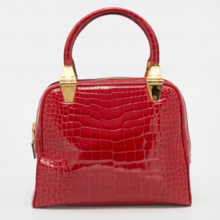 Doté d'une silhouette minimale, ce fourre-tout Tom Ford incarne un attrait intemporel et un luxe inégalé. Réalisé en cuir de crocodile, il est l'accessoire de toutes les saisons. Le sac se présente dans une splendide couleur rouge avec des