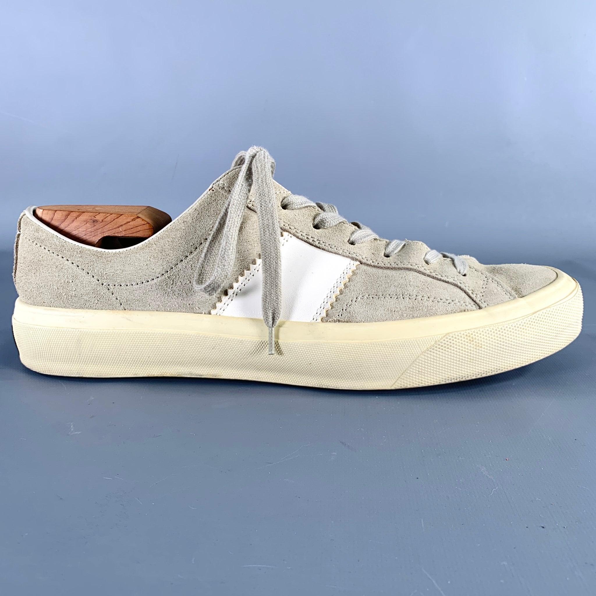 TOM FORD sneakers in a grey taupe suede featuring white side stripe detail, low top style, and lace-up closure. Made in Italy.Very Good Pre-Owned Condition. Minor signs of wear. Rubber sole of right shoe is yellower than the left sole, as is.
