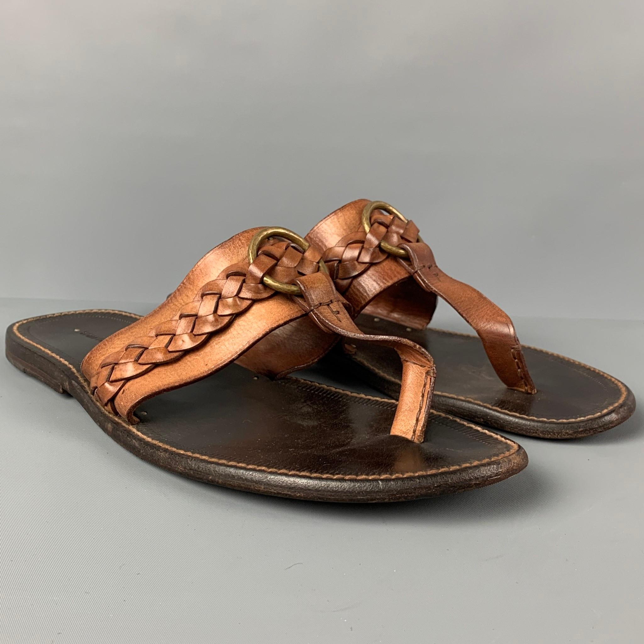 TOM FORD sandals comes in a tan leather featuring a braided detail, brass ring detail, and a t-strap detail. Made in Italy. 

Very Good Pre-Owned Condition.
Marked: 10

Outsole: 12 in. x 4.5 in. 