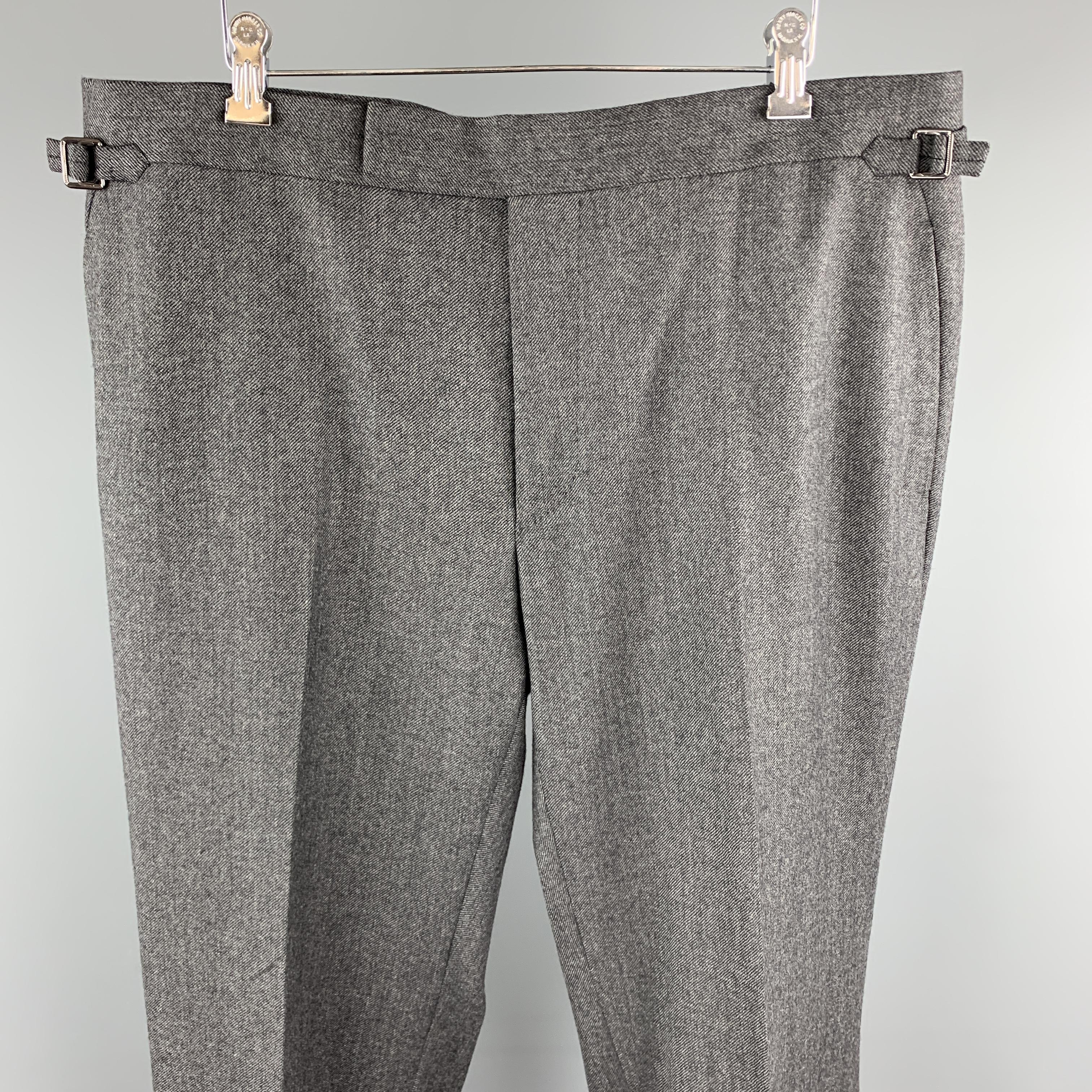 TOM FORD dress pants come in dark heathered gray wool blend twill with a flat front, tab waistband and adjustable side tabs. 

Excellent Pre-Owned Condition.
Marked: (size tag removed)

Measurements:

Waist: 40 in.
Rise: 12 in.
Inseam: 32 in.