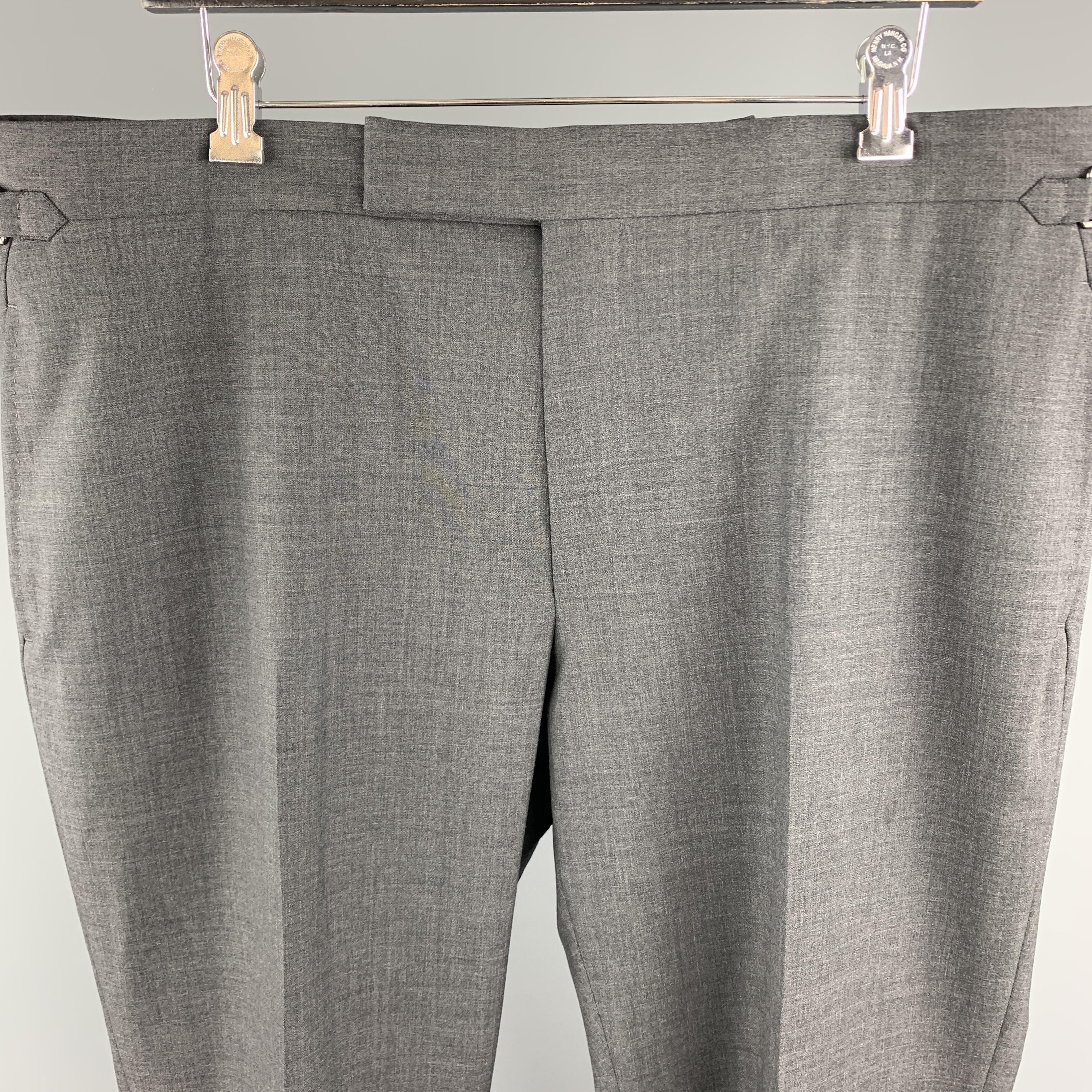 TOM FORD dress pants come in dark heathered gray wool gabardine with a flat front, tab waistband, cuffed hem, and adjustable side tabs. Made in Switzerland.

Excellent Pre-Owned Condition.
Marked: IT 58 R

Measurements:

Waist: 40.5 in.
Rise: 11.5
