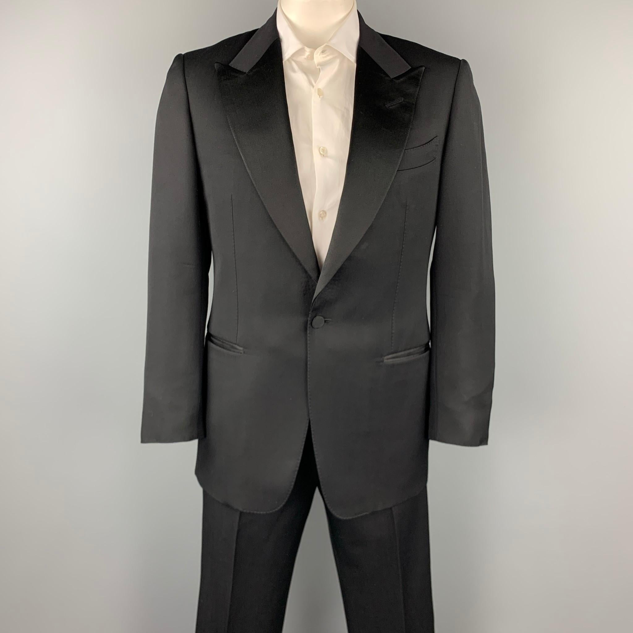 TOM FORD suit comes in a black wool / mohair with a full liner and includes a single breasted, single button sport coat with a peak lapel and matching flat front trousers.

Very Good Pre-Owned Condition.
Marked: 50