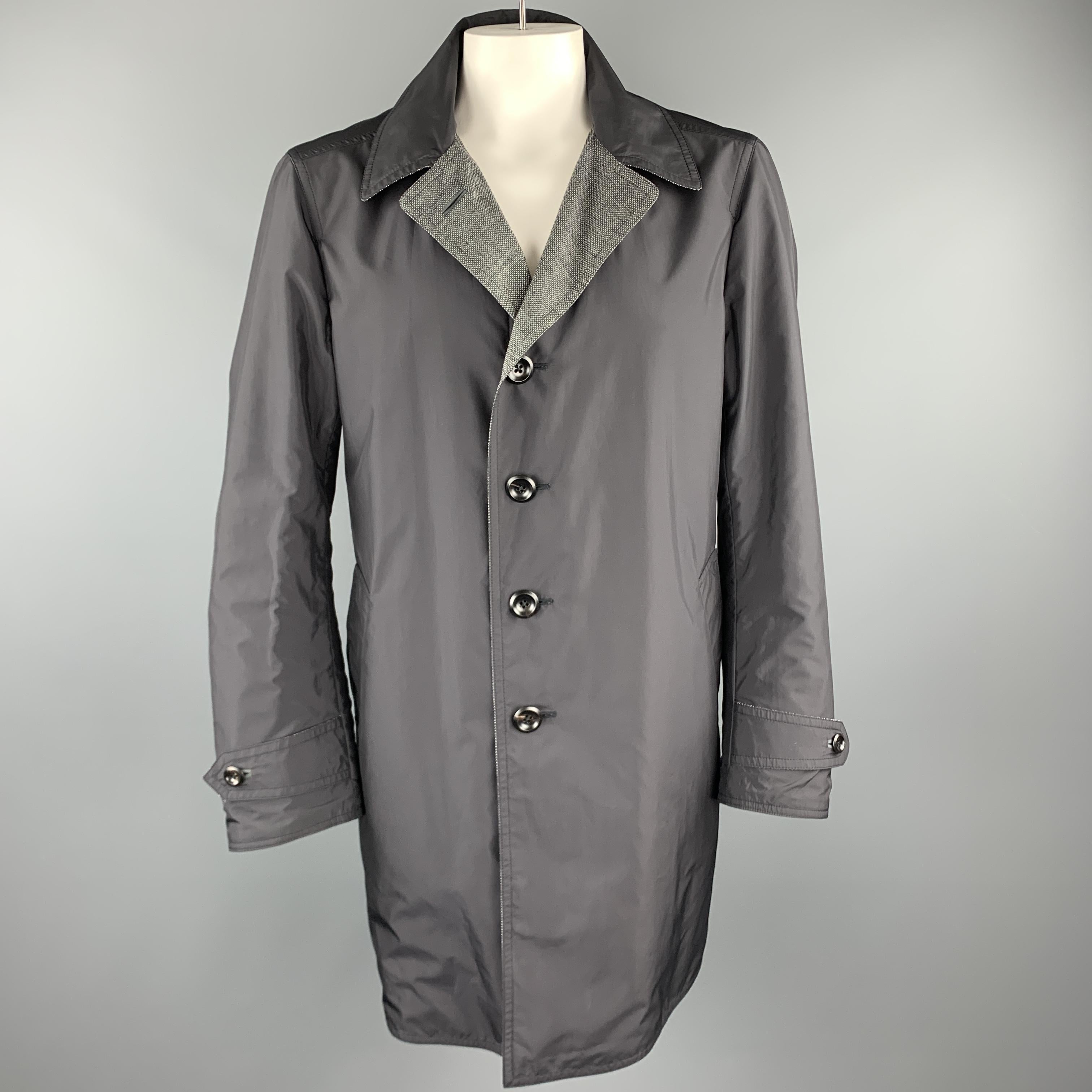 TOM FORD trench coat comes in wool, linen, silk blend heathered woven material with a pointed collar hidden placket button front, slated pockets,tab cuffs sleeves, and reverse black waterproof side. Made in Italy.

Excellent Pre-Owned Condition.