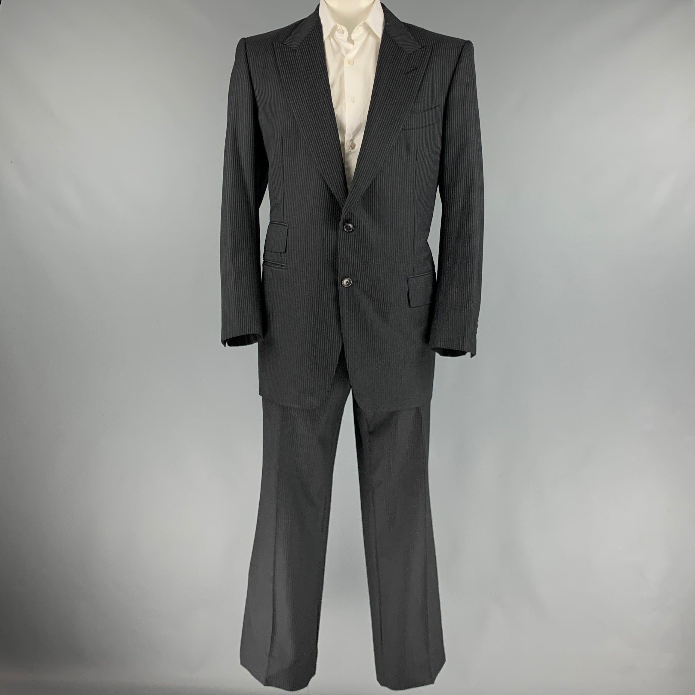 TOM FORD suit
in a black and grey pinstripe wool with a full liner and includes a single breasted, double button sport coat with peak lapel and matching flat front trousers. Made in Italy.Very Good Pre-Owned Condition. 

Marked:   58L