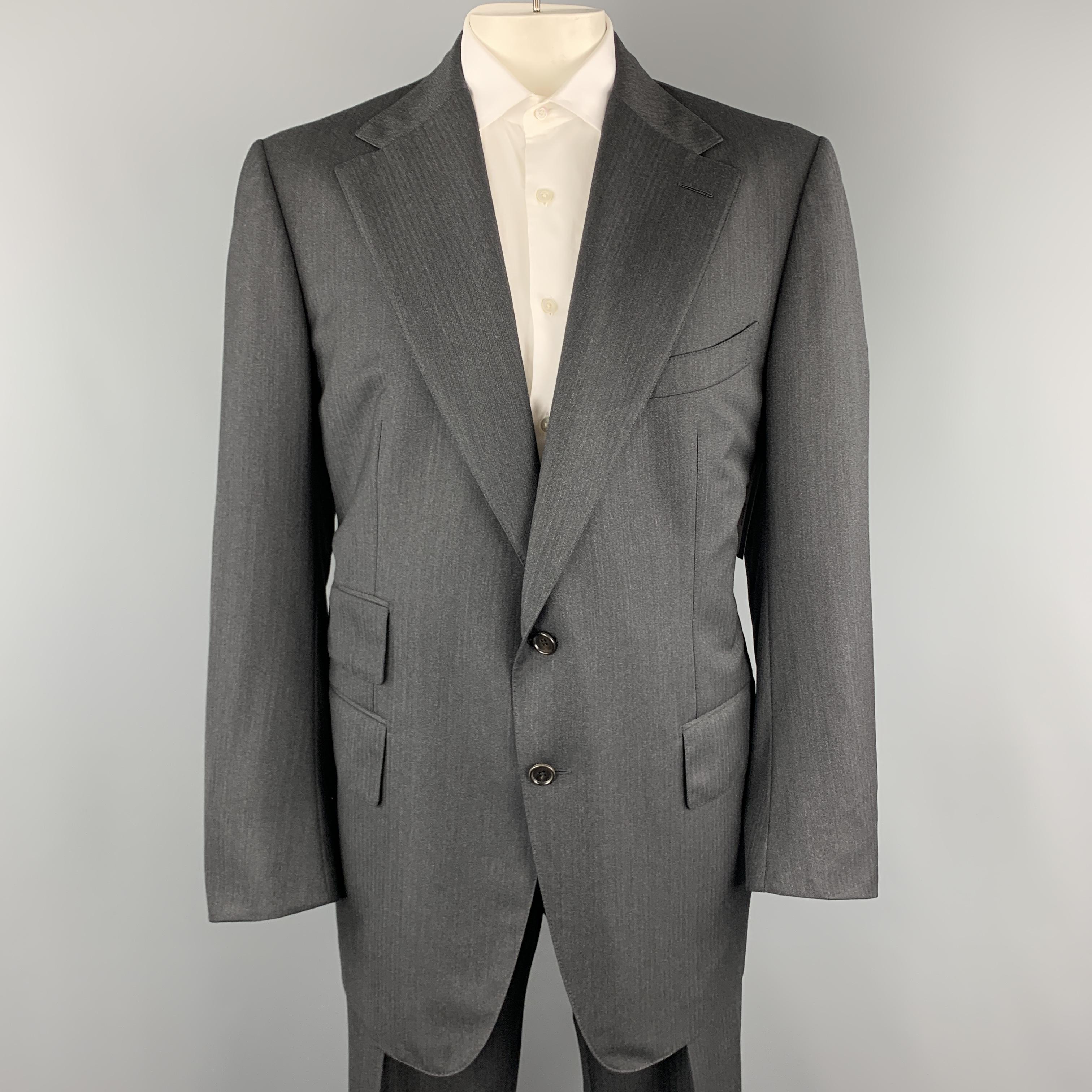 TOM FORD suit comes in charcoal gray wool herringbone and includes a single breasted, two button sport coat with a notch lapel and matching pleated front cuffed trousers with side tabs. Altered. As-is. Made in Italy.

Excellent Pre-Owned