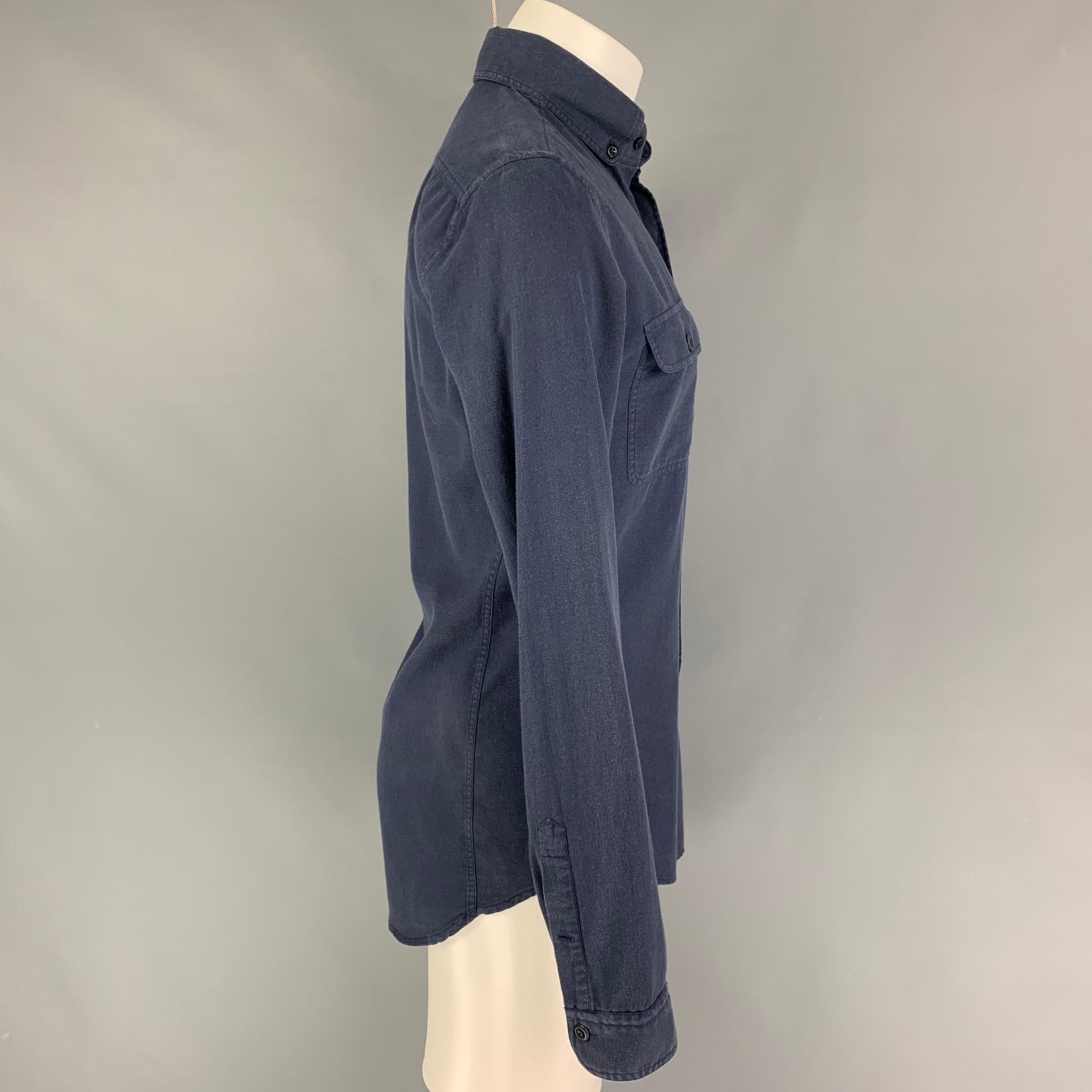 La chemise à manches longues de TOM FORD est en coton marine et présente un col boutonné, des poches plaquées et une fermeture à bouton. 

Très bon état d'origine. Étiquette de tissu enlevée.
Noté : 40/15

Mesures :

Épaule : 17.5 in.
Poitrine : 40