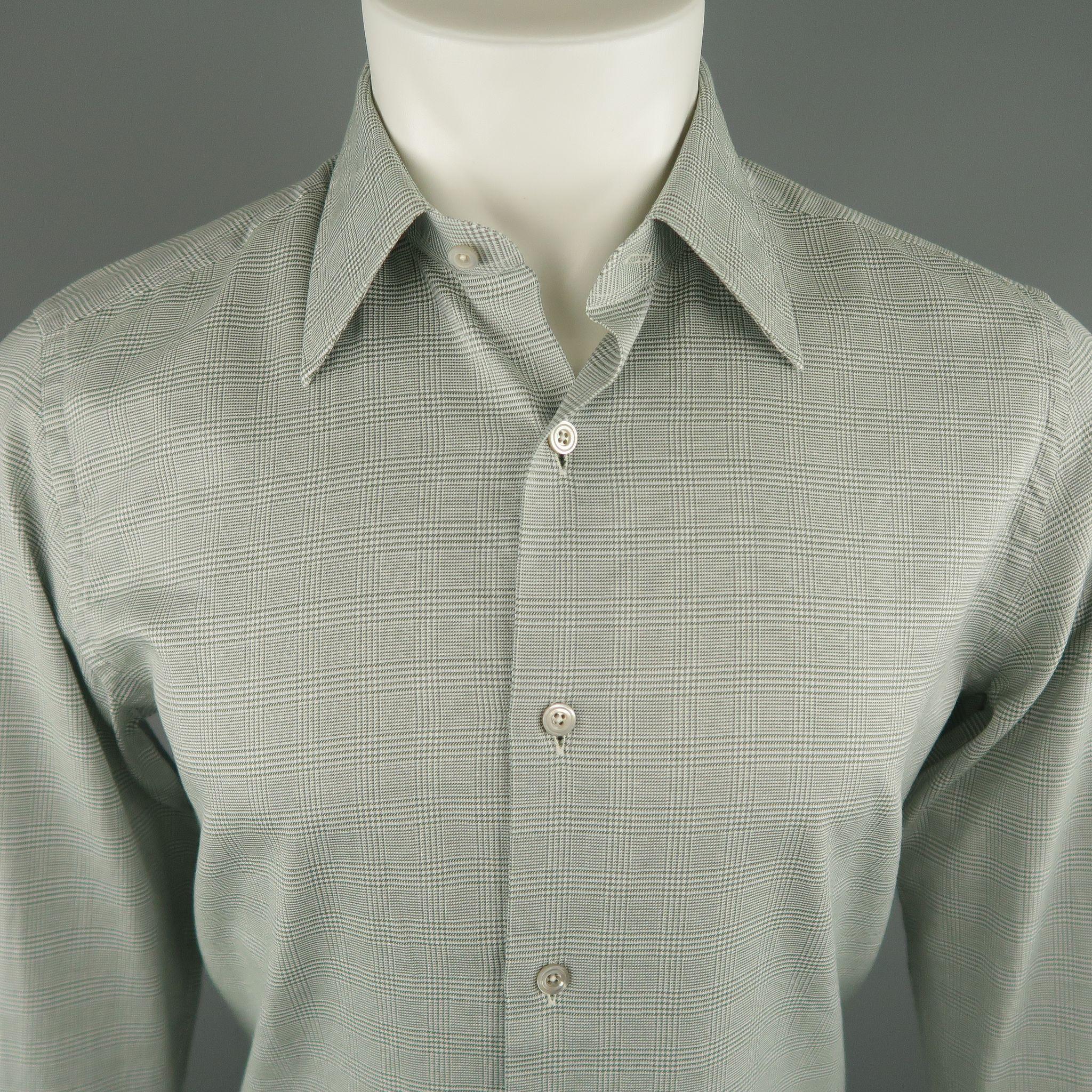 La chemise à manches longues TOM FORD se décline dans un ton olive en coton écossais. Elle présente un col pointu, des poignets boutonnés et un boutonnage. Fabriqué en Suisse.
 
Nouveau avec des étiquettes.
Marqué : 39 - 15 1/2
 
Mesures :
