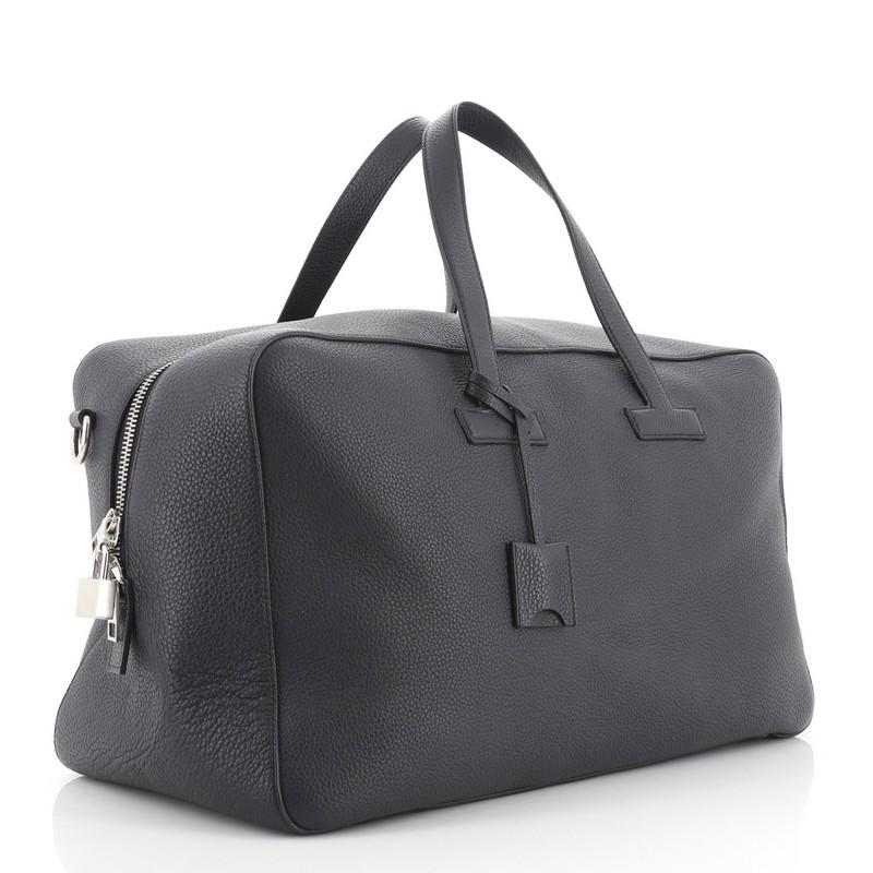 This Tom Ford T Duffle Bag Leather Medium, crafted from blue leather, features dual top handles and silver-tone hardware. Its zip closure opens to a neutral fabric interior with zip and slip pockets. 

Estimated Retail Price: $3,750
Condition:
