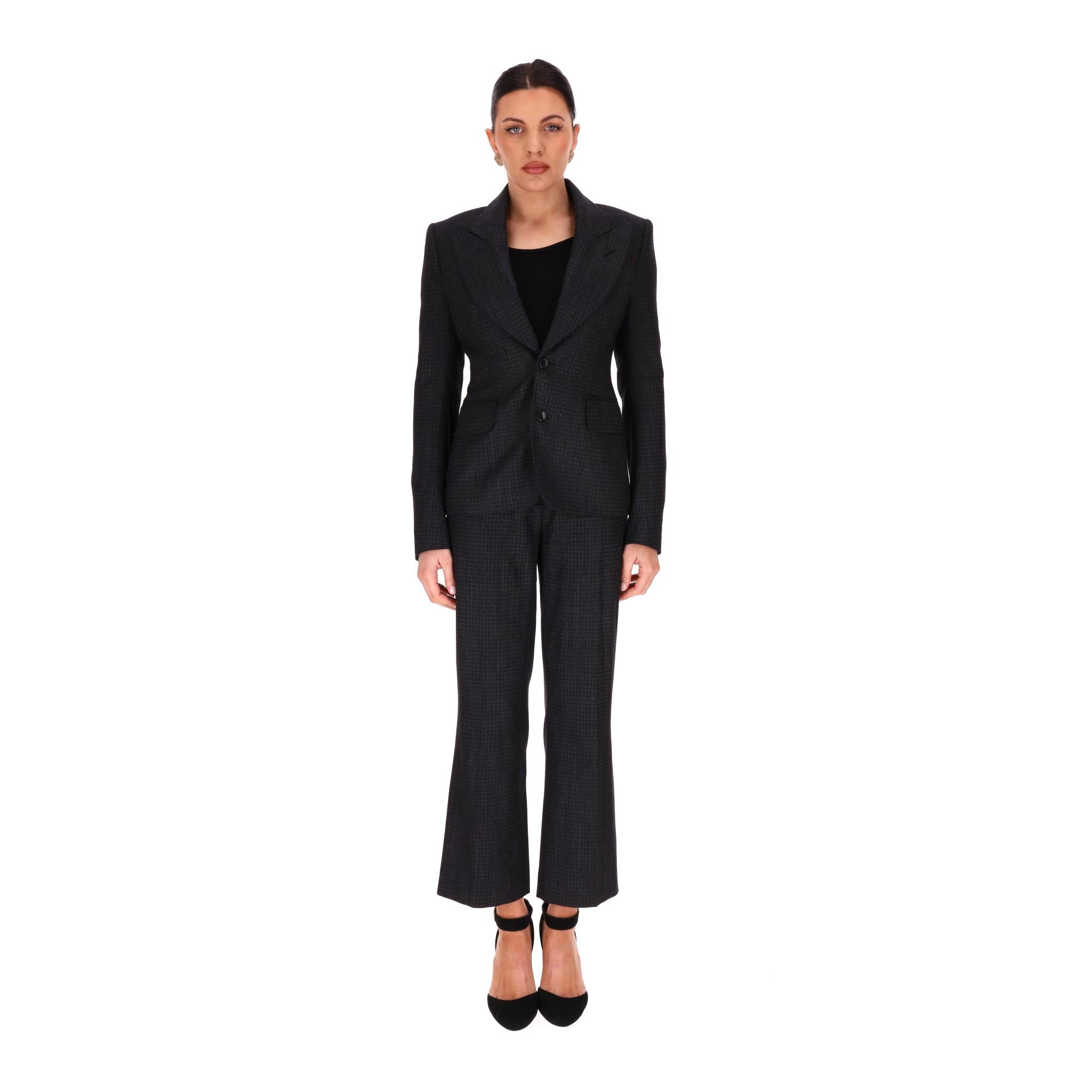 Tom Ford: abito a due pezzi in seta e misto lana

Abito sartoriale grigio scuro in misto seta e lana con motivo a quadri tonali.

Giacca monopetto con ampi revers a lancia e tasche con patta sul davanti.

Pantaloni a gamba dritta con tasche a