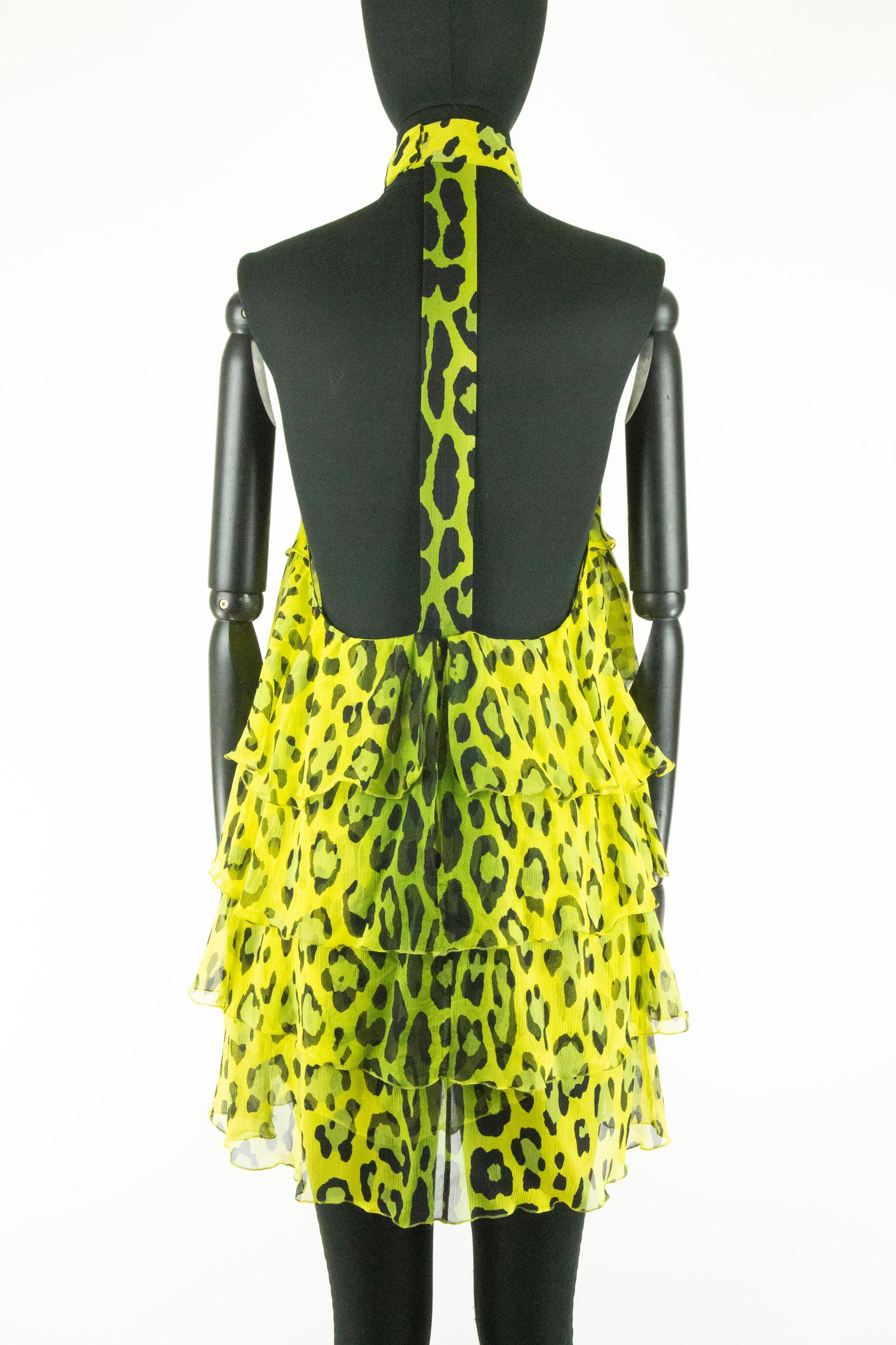 This Tom Ford halter neck dress features a bright and eye-catching print of chartreuse green and yellow leopard print. The body is covered in layered ruffles right up to the tight collar. The rear features a strap running down the open back and is