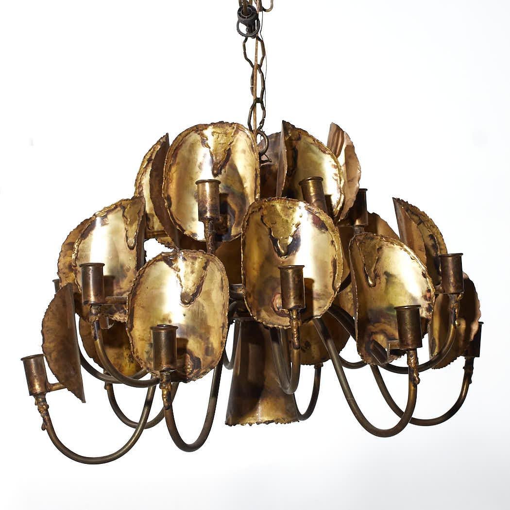 Tom Green for Feldman Mid Century Brass Brutalist 18 Light Chandelier

This chandelier measures: 25 wide x 25 deep x 15 inches high

We take our photos in a controlled lighting studio to show as much detail as possible. We do not photoshop out