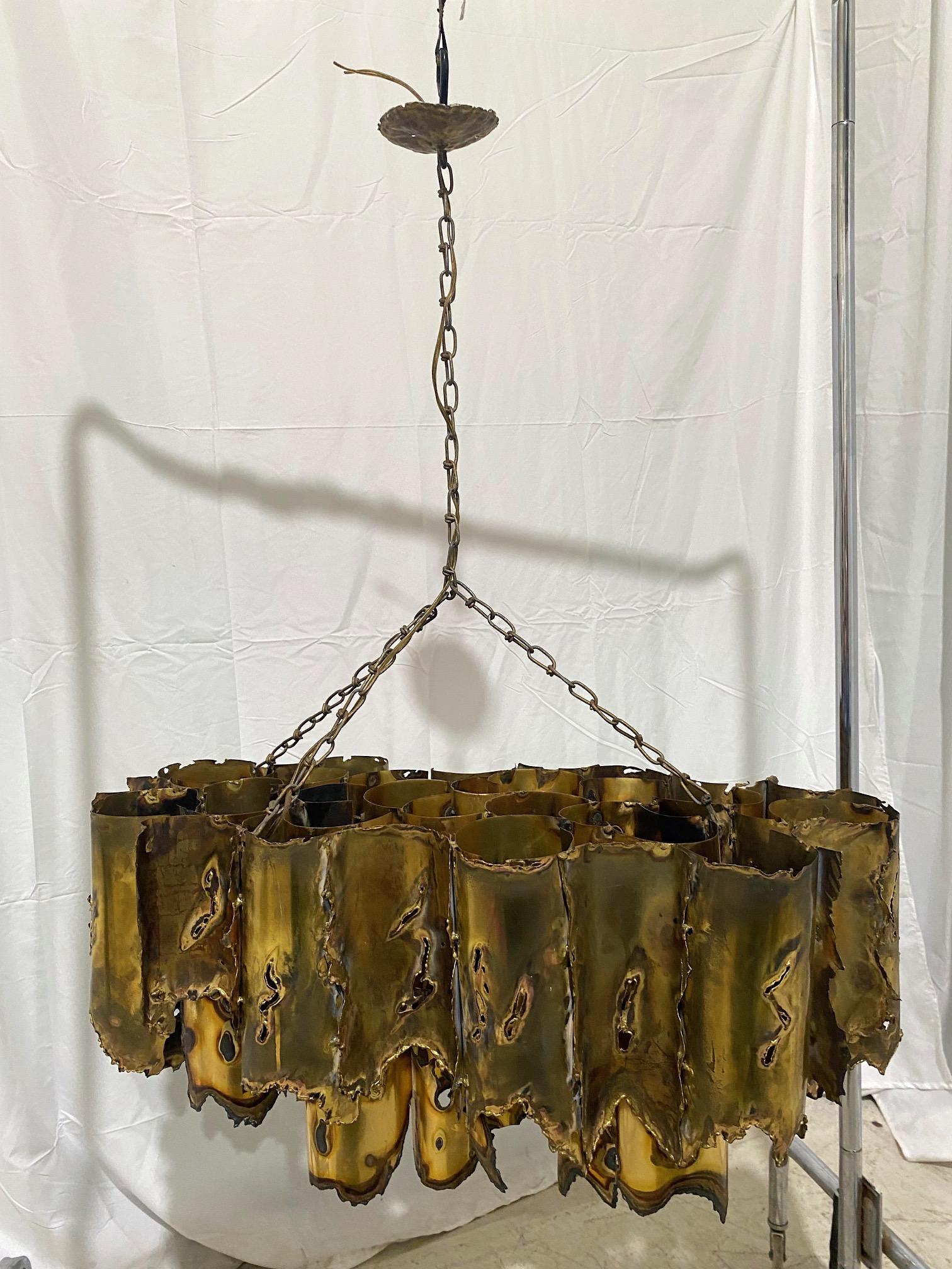 Los Angeles–based metal sculptor and designer Tom Greene created this fabulous brutalist chandelier for the Feldman Lighting Company in the late 1960s-early 1970s. He used an oxyacetylene torch to cut and create his large organic sculptures and