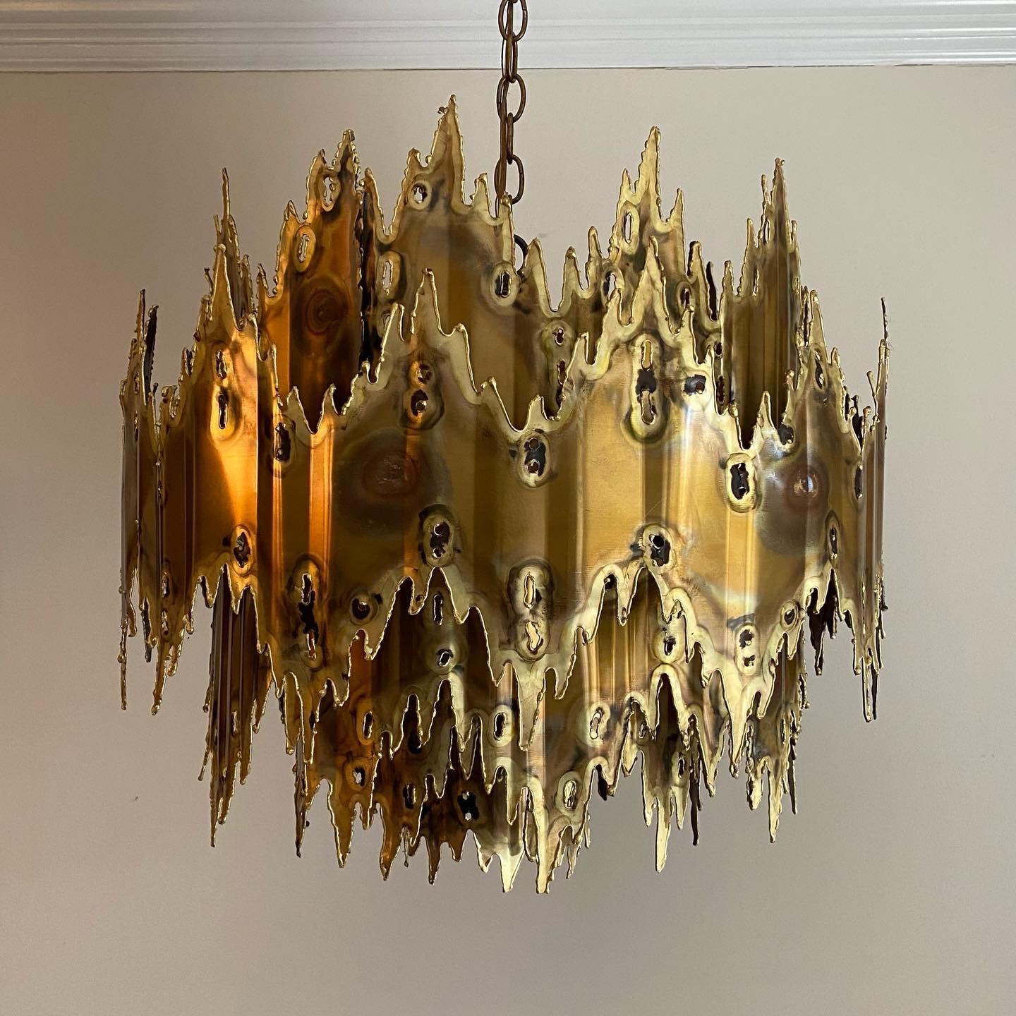 A fine example by Tom Greene in torch cut brass with six bulbs around and one pointing down. Retains the original canopy.
