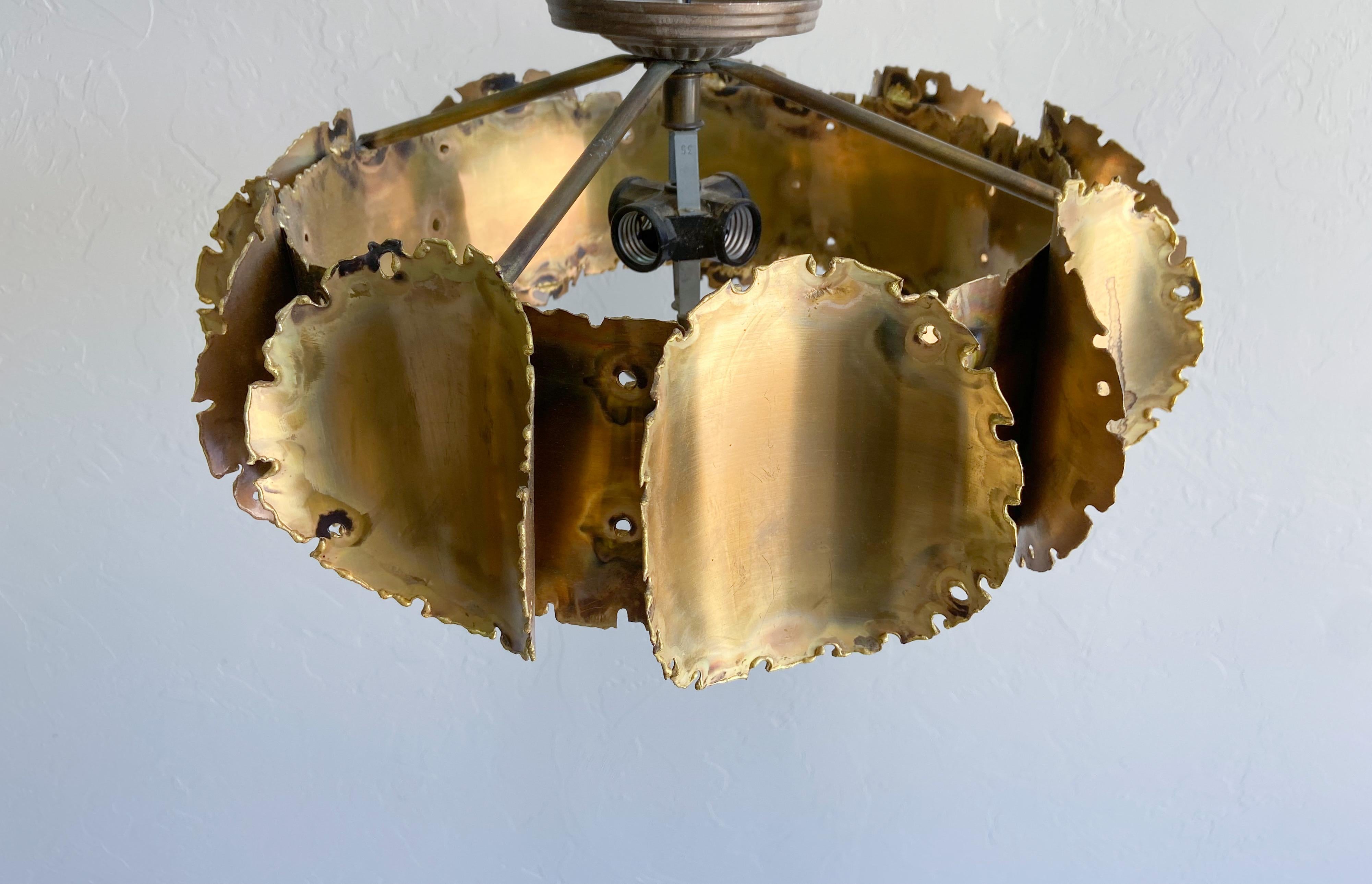 A wonderful handmade, torch-cut brass pendant light designed by Tom Greene and produced by Feldman Lighting. 

A unique and eye-catching pendant light that is as much an art piece as it is lighting. This flush mount light houses four standard