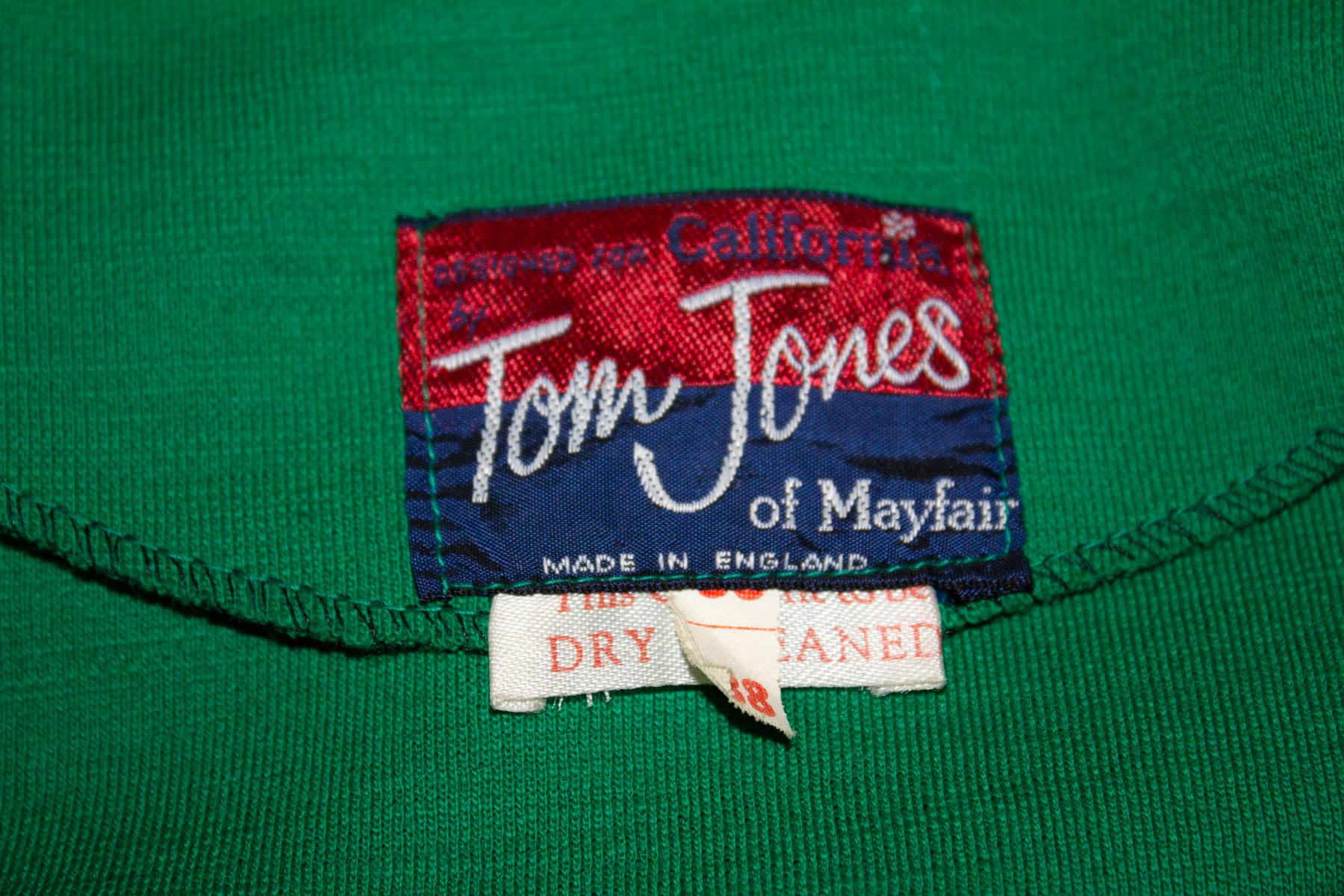 A fun and easy to wear vintage green jersey dress by Tom Jones of Mayfair. The dress has a great collar, button front opening and is unlined. 
Size 38 , measurements bust 38'', length 41''
