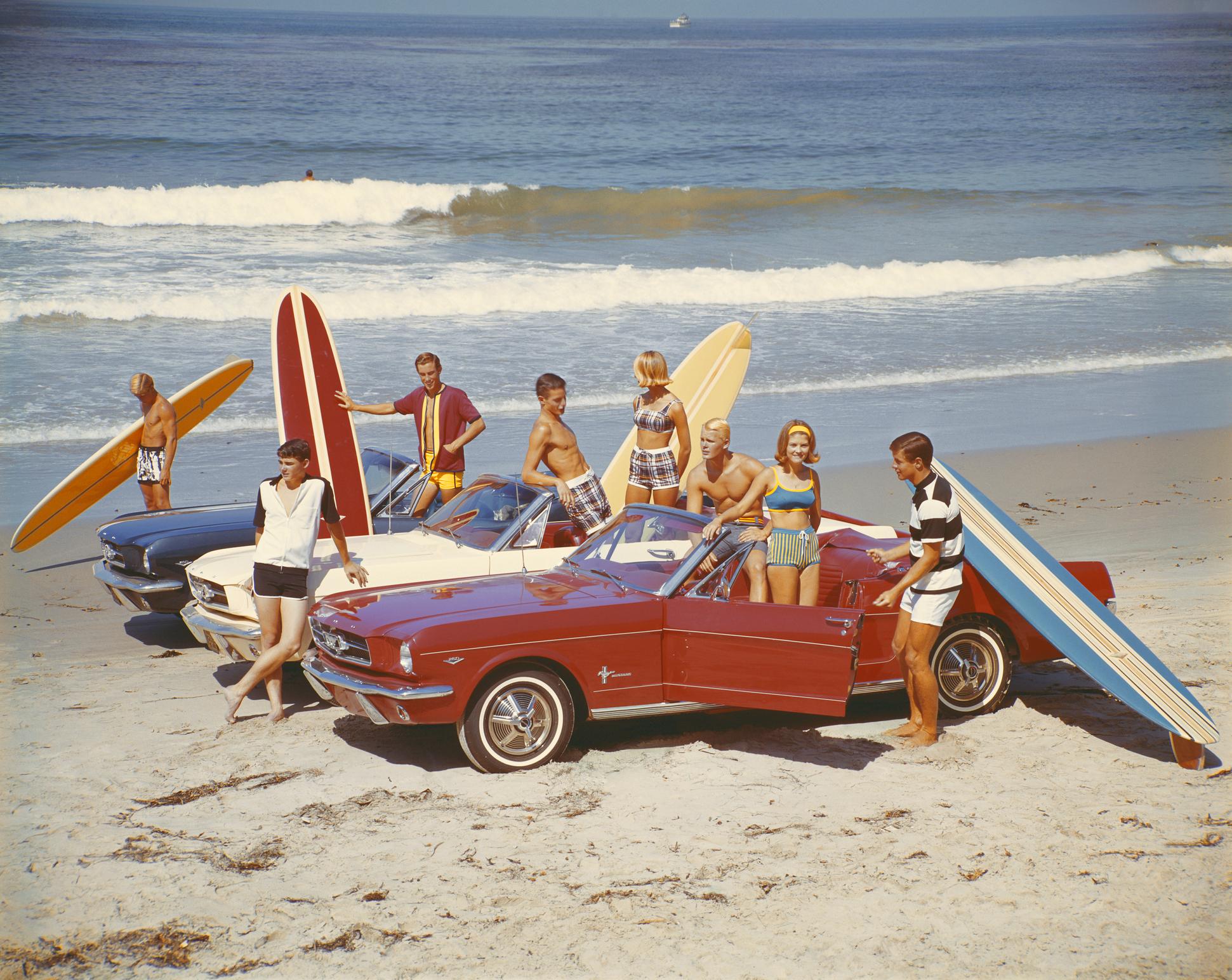 Tom Kelley Figurative Photograph - Friends with surfboards in Ford Mustangs