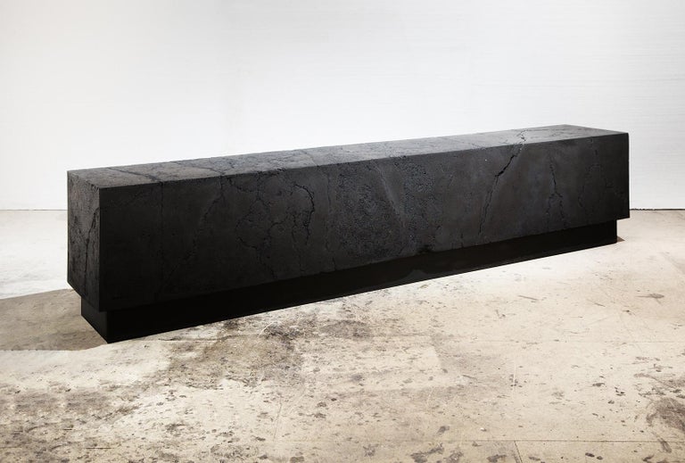 Coal, Jesmonite, wood, steel. 45 cm × 220 cm × 35 cm.
Carbon Bench is one of Tom Price's 'hybrid' artworks sitting halfway between art and design: the piece can be seen exclusively as a sculpture or can also serve as a bench. Here, the dark and