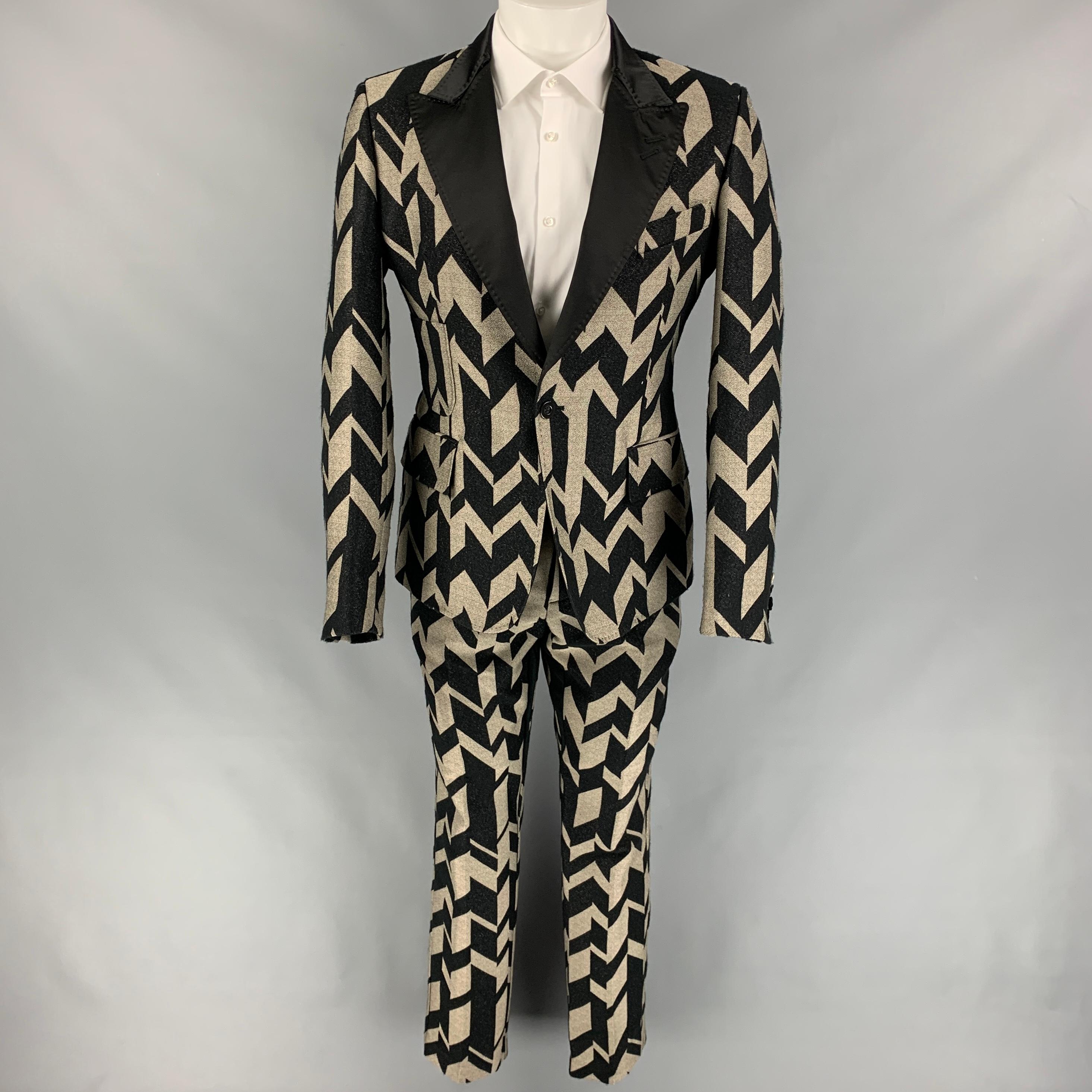 TOM REBL suit comes in a black & gold chevron print polyester blend with a full liner and includes a single breasted, single button sport coat with peak lapel and matching flat front trousers. Made in Italy.

Very Good Pre-Owned Condition. Pants