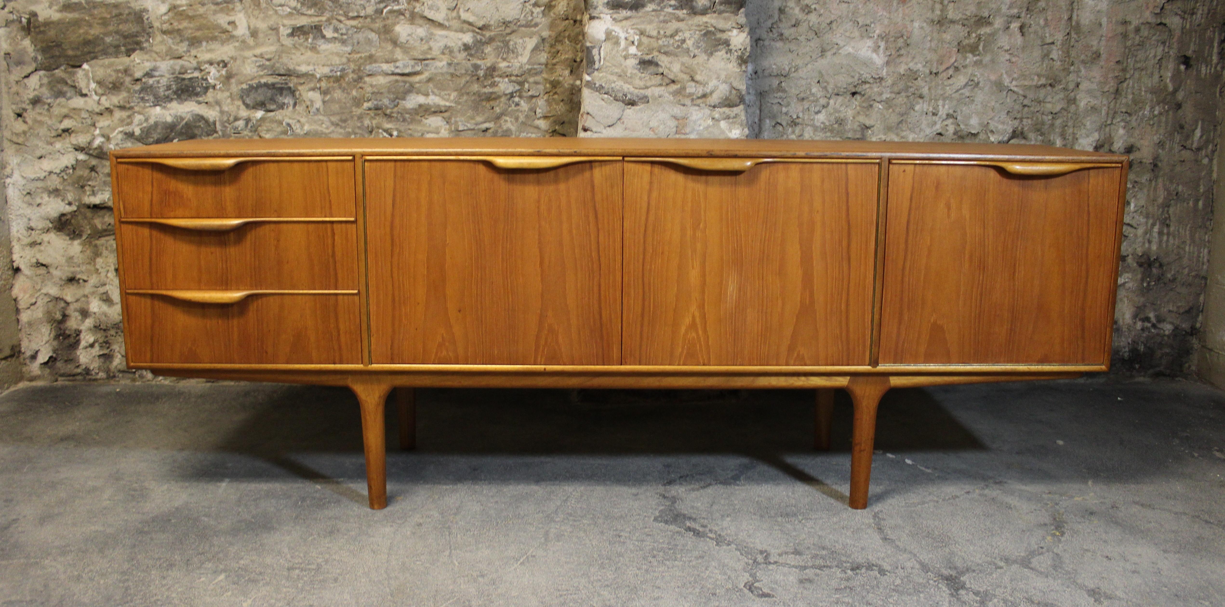 Sleekly and functionally designed teak sideboard with organically shaped handles and elegant tapered legs. 

 