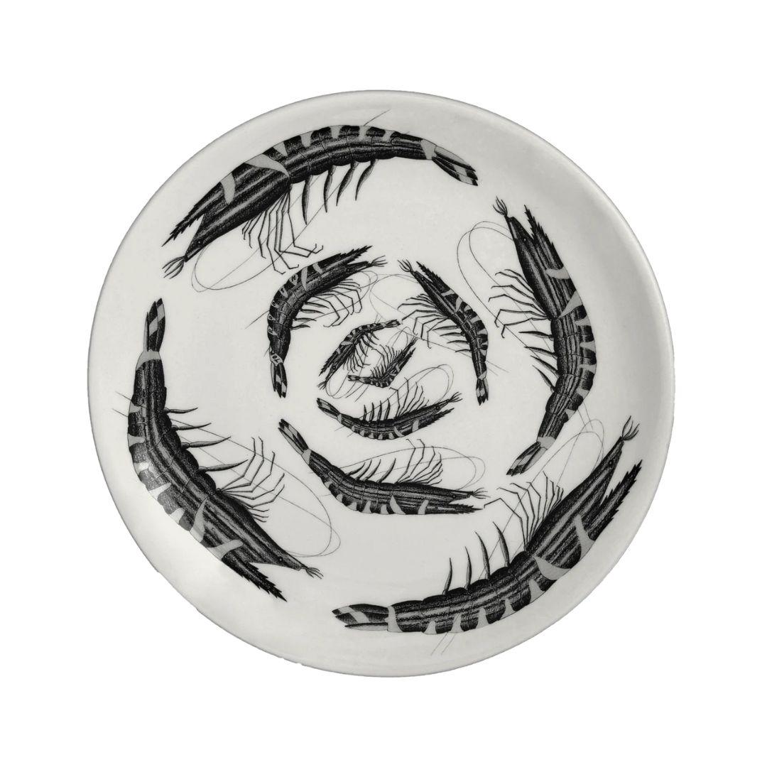 Esta fuente de cerámica hecha a mano por el artista británico Tom Rooth presenta una atrevida espiral de gambas intrincadamente ilustradas, con el juguetón título de Langostinografía. Realizado en el característico estilo naturalista en blanco y