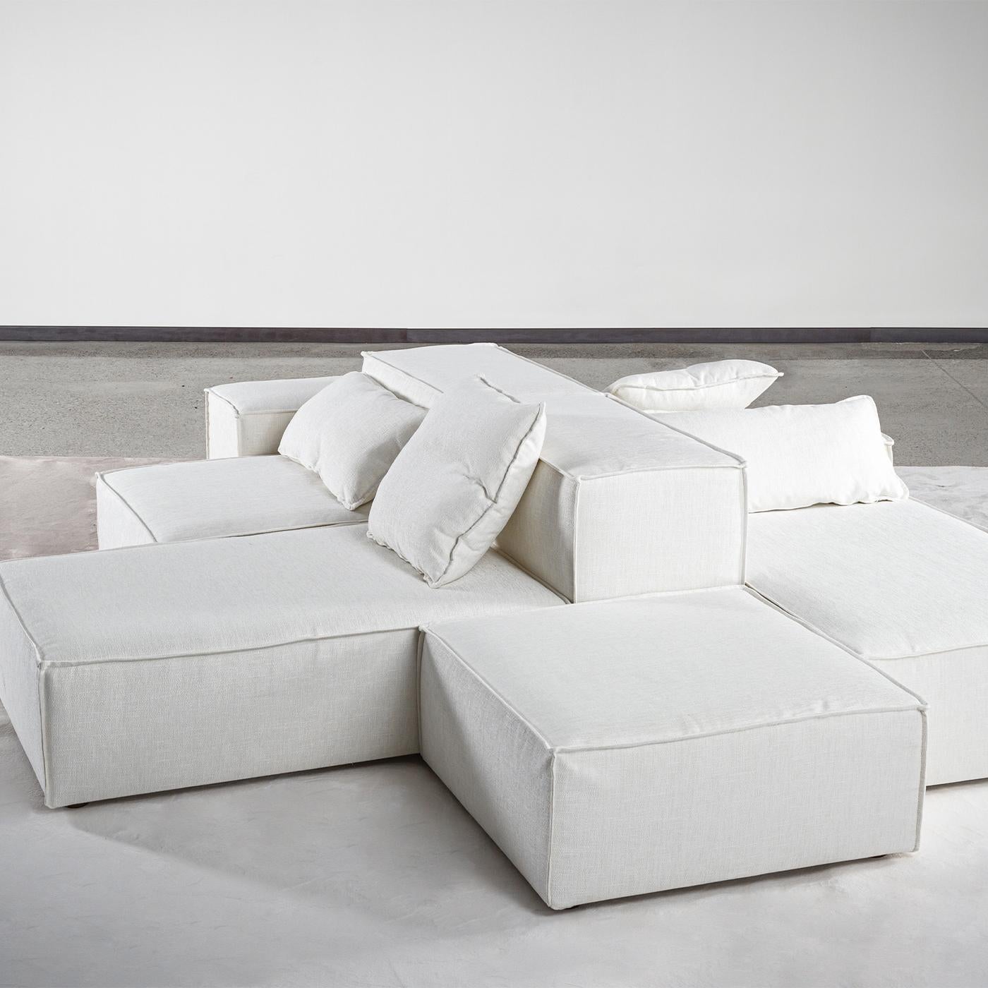 This soft modular white 100% Italian sofa combines great comfort and a unique geometrical pattern. Composed by different pieces of furniture connected by specific hooks, it features a minimal design enhanced by sartorial touches such as the pinched