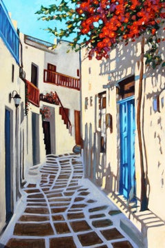 Scène de rue « Colors of Mykonos » avec fleurs rouges et porte bleue