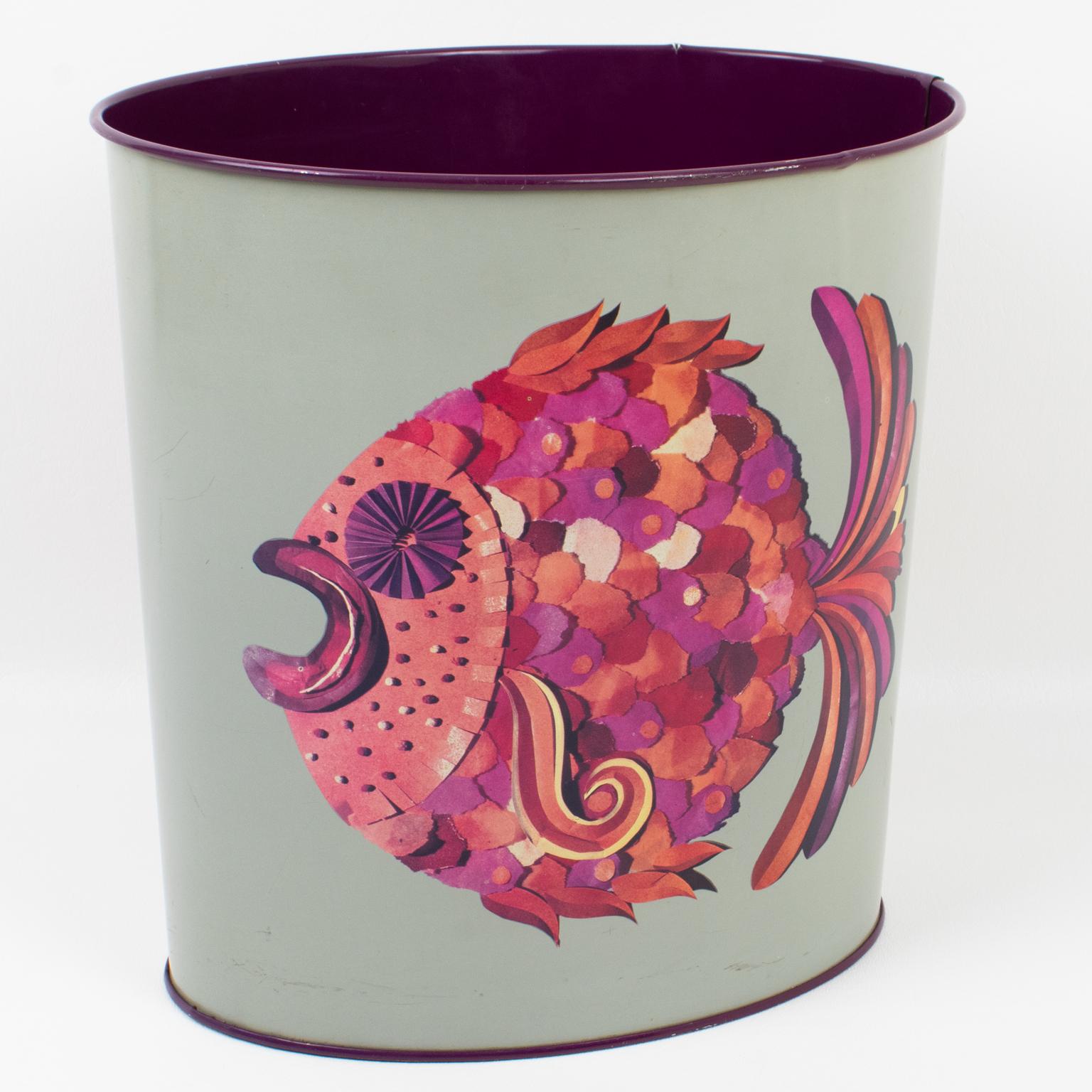 A functional 1960s Mid-Century-Modern desk accessory, office waste-basket designed by Tomado, Holland. The oval shape boasts a light gray metal structure with a typical polychrome modernist design of exotic fishes in purple, pink, and red colors.