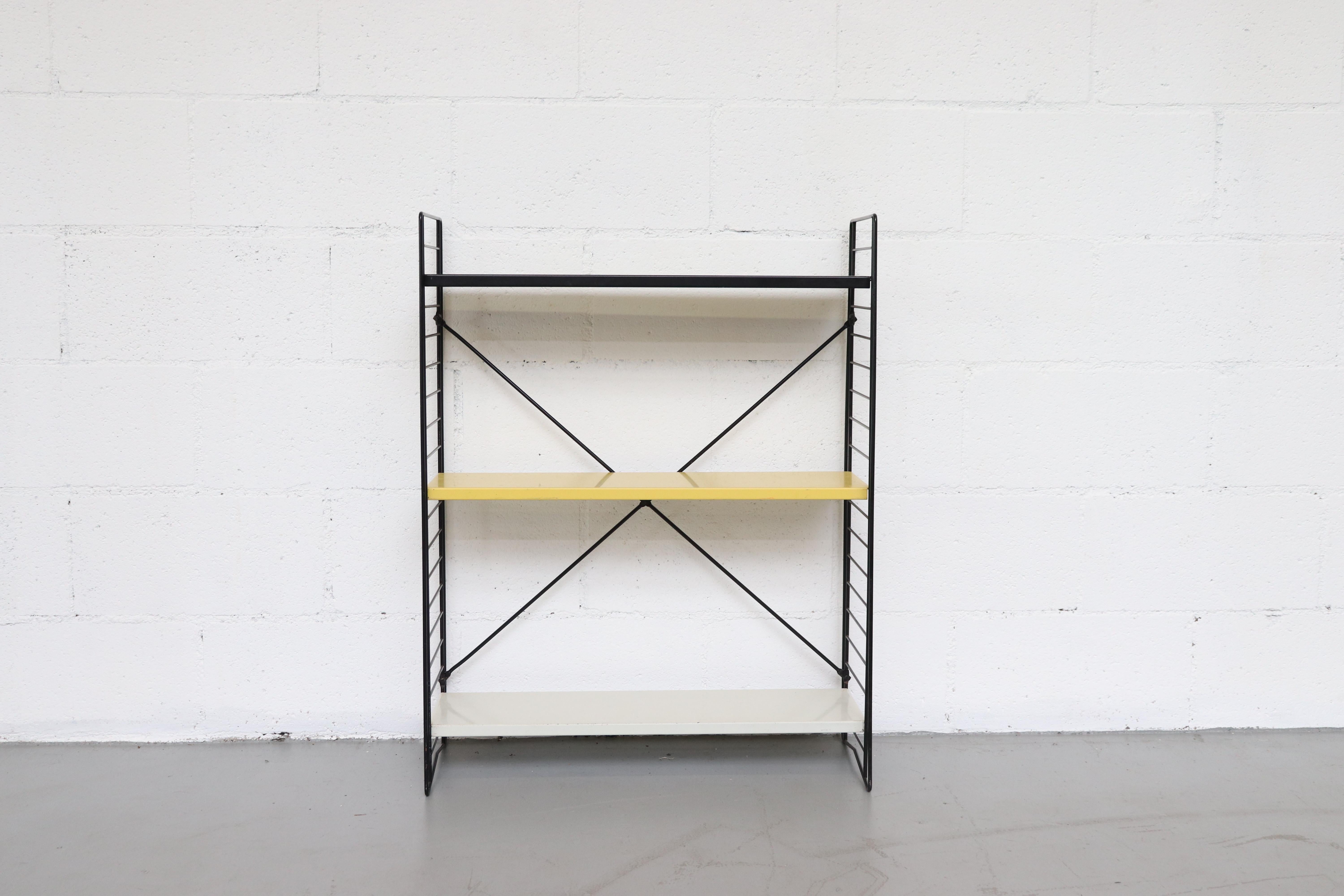 Multicolored black, yellow, white enameled metal shelves with black wire stands. Shelves are moveable.