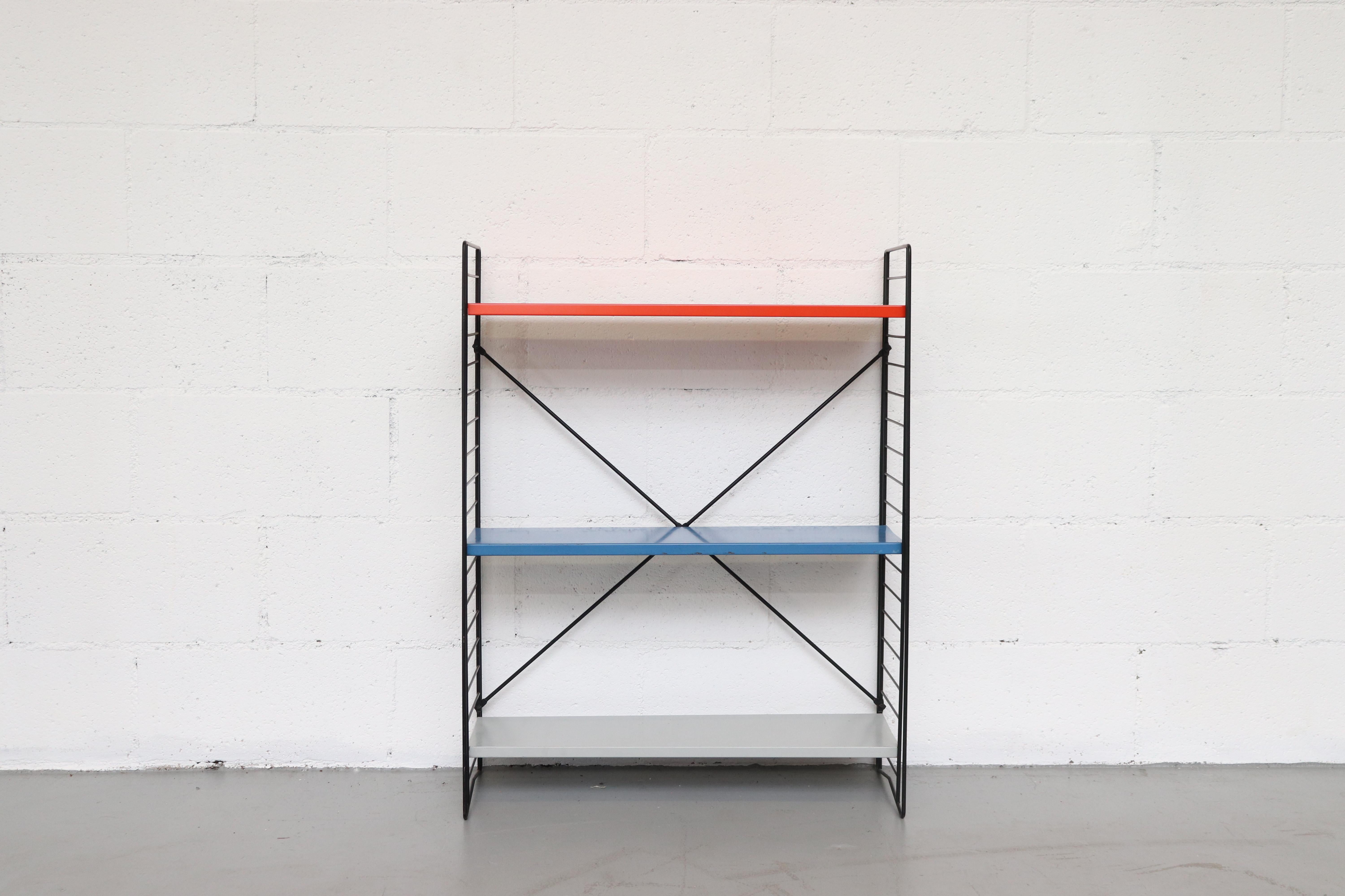 Multicolored orange, blue, grey enameled metal shelves with black wire stands. Shelves are moveable. Other color combinations available, listed separately. Can ship flat.