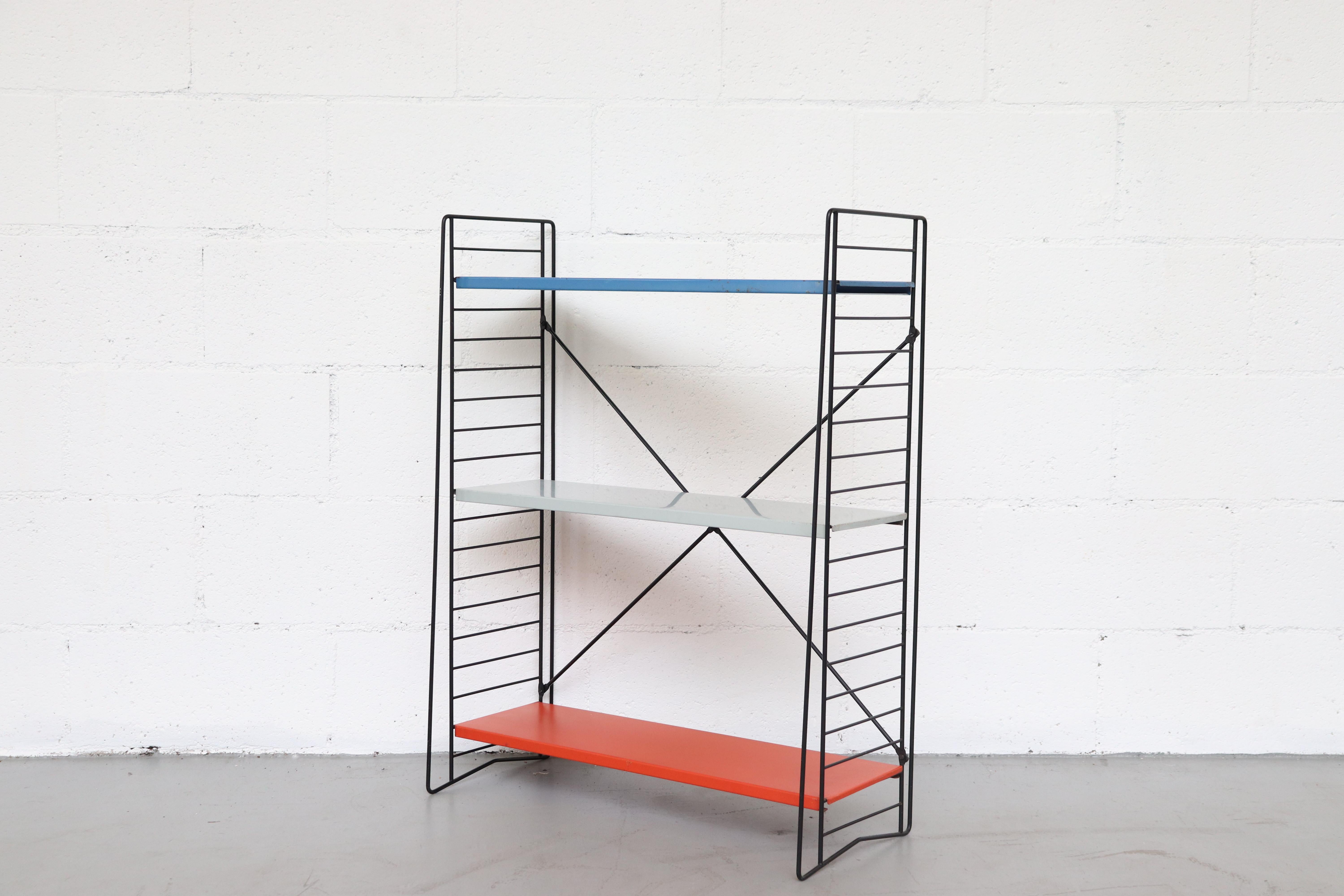 Tomado single standing industrial book shelf by Jan van der Togt; multicolored blue, grey, orange enameled metal shelves with black wire stands. Shelves are moveable.