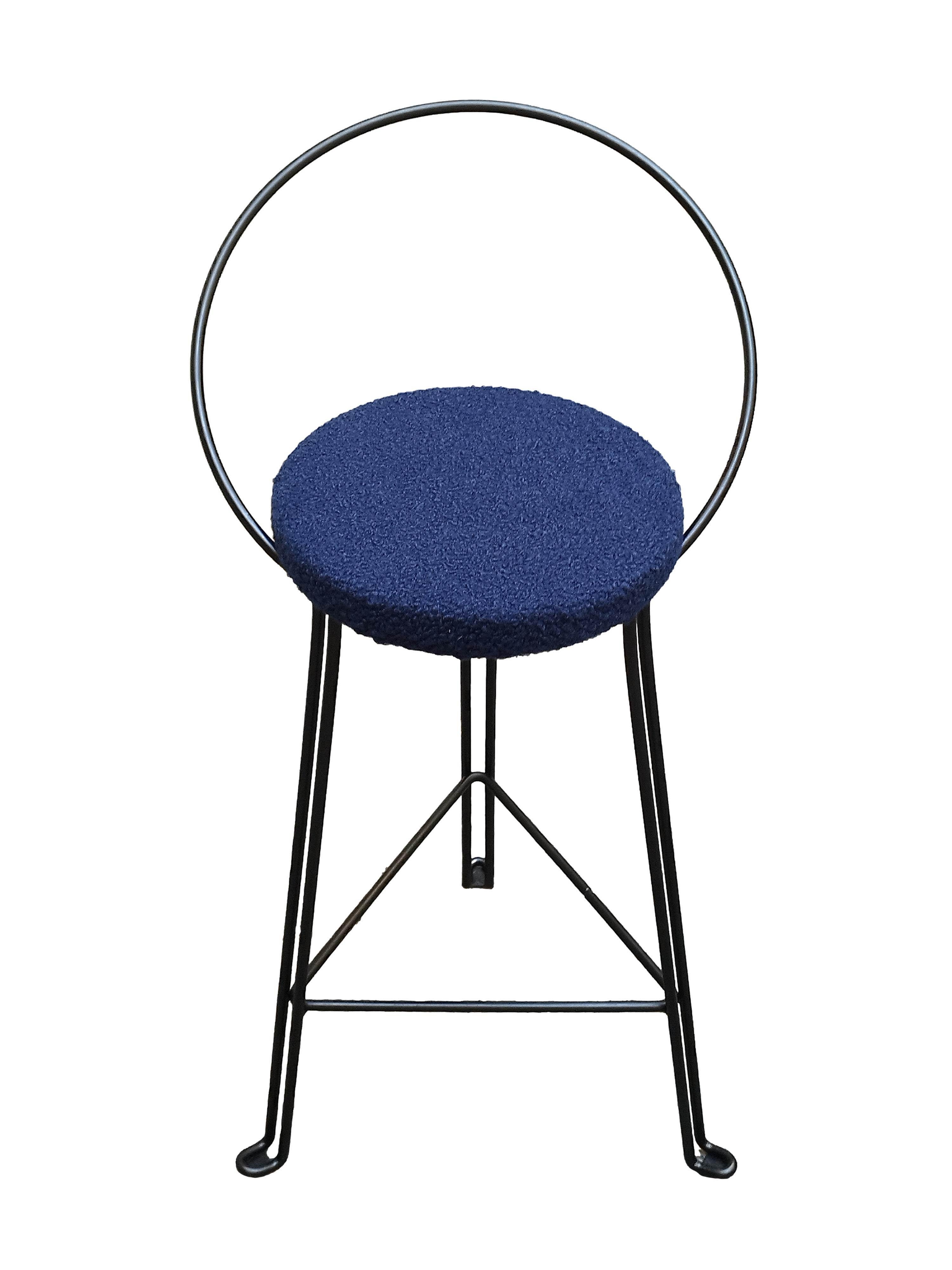 Ce tabouret industriel robuste de style Tomado est doté d'une assise ronde recouverte de tissu bleu et d'une structure en fil d'acier. 