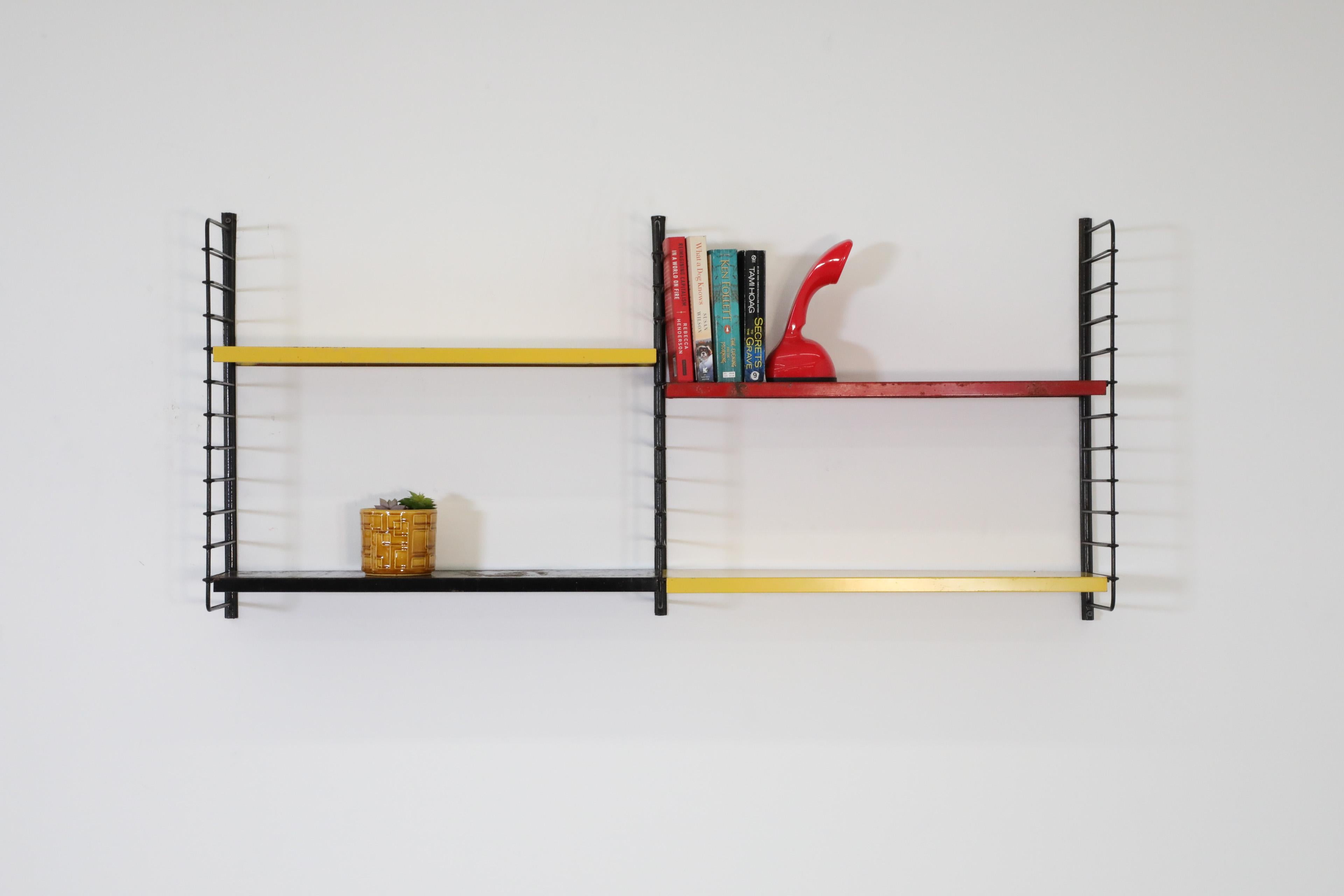 Dutch Mid-Century, Tomado style, industrial two section wall mounted shelving with yellow, red and black shelves on black enameled metal risers. In original condition with visible wear consistent with its age and use. Other similar shelves
