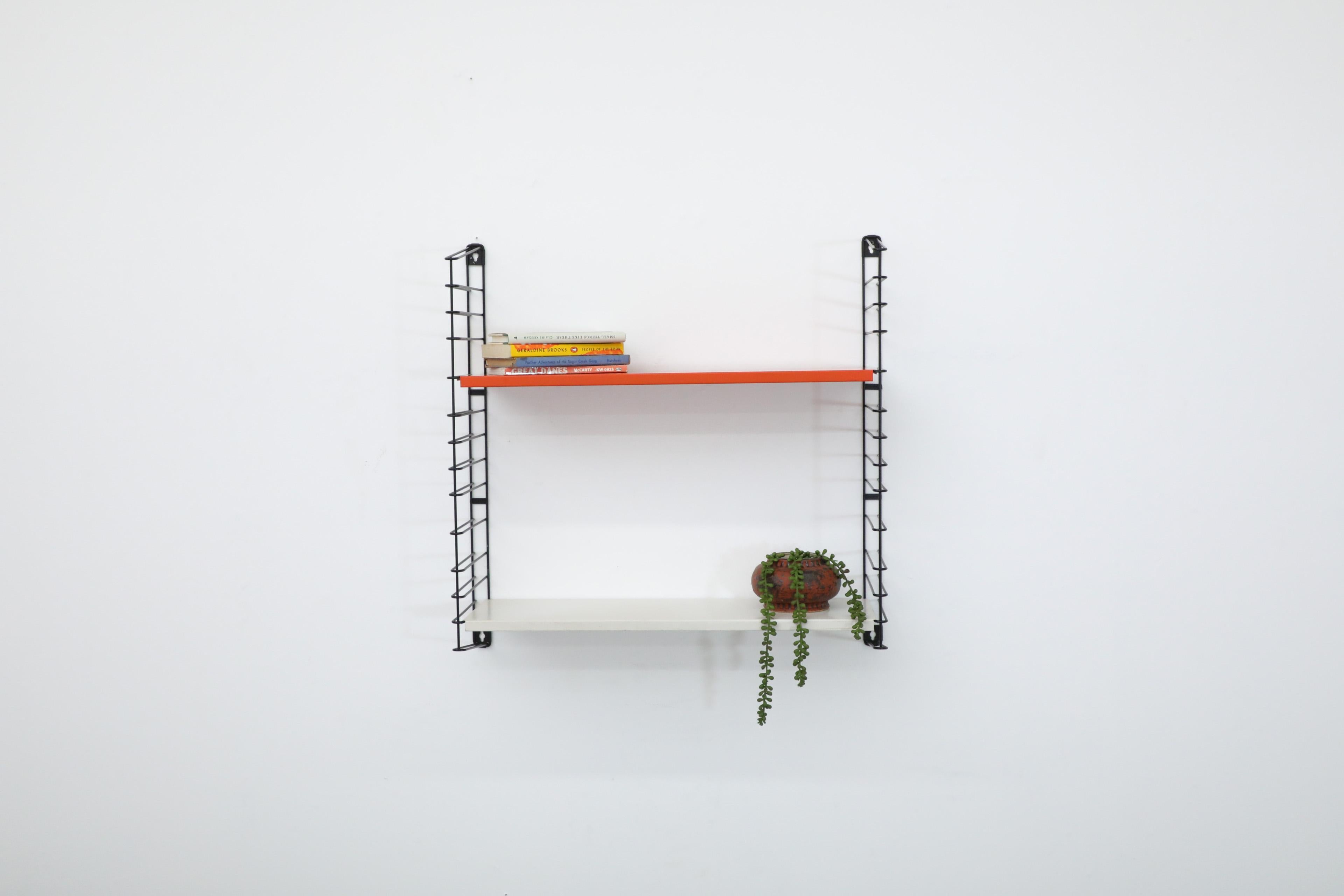 Tomado single section wall mounted shelving unit with white and red shelves on black wire risers. In original condition with visible wear consistent with its age and use. Similar shelves also available and listed separately. Ships flat.