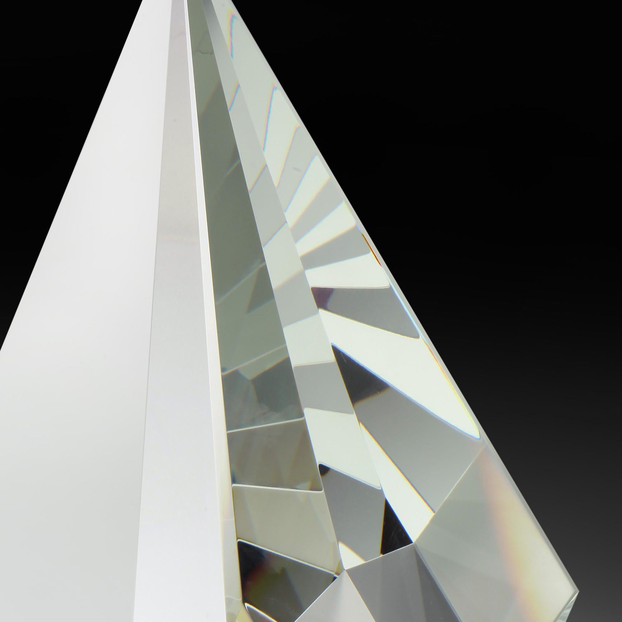 This abstract optic glass sculpture is noteworthy for both its geometric shape and purity. Brzon uses pure optic glass, void of any defects, which enables its perfection to shine through. The cuts and contours of the design enhance the reflections