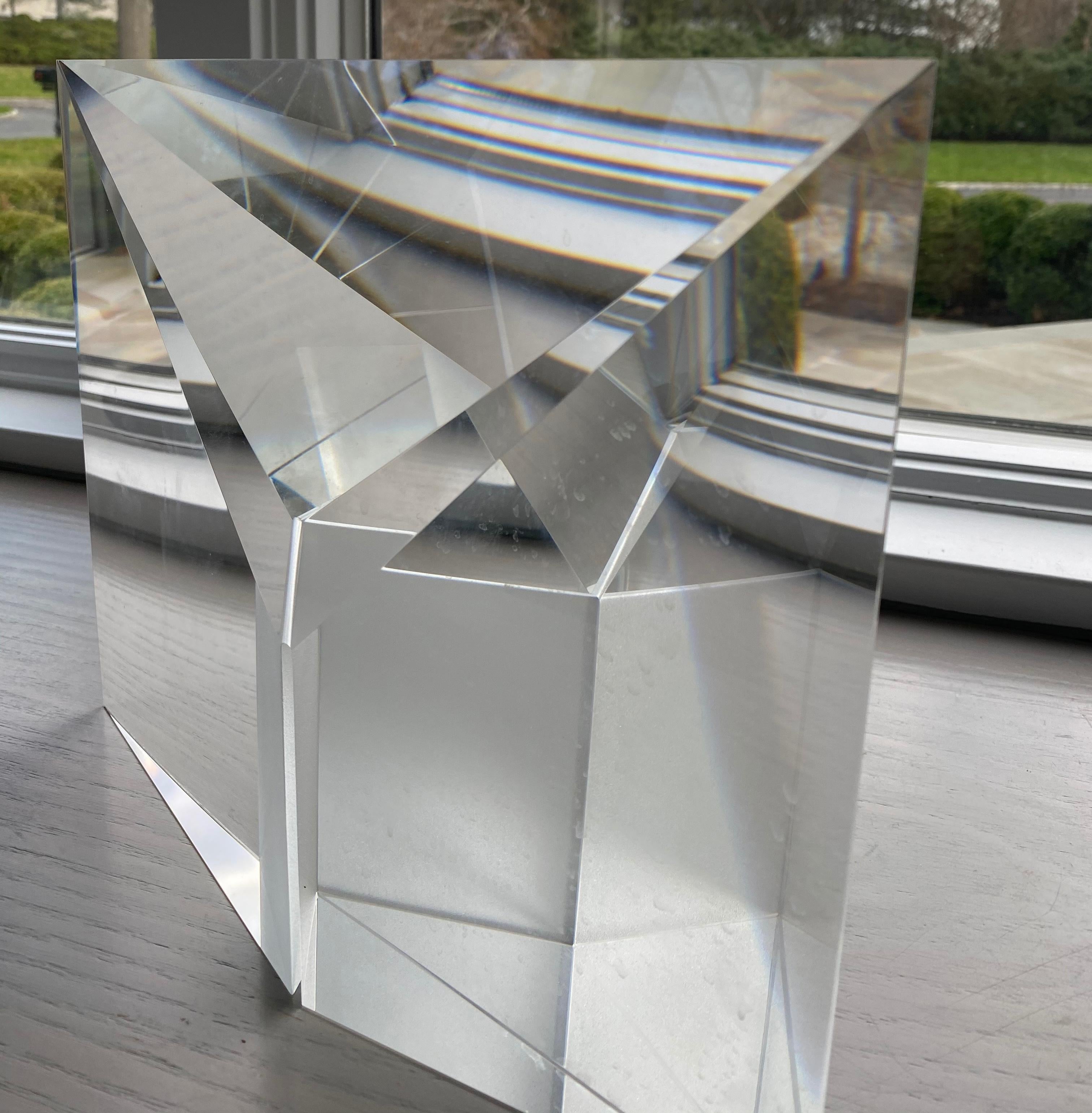 This abstract optic glass sculpture created by Czech artist Tomas Brzon is noteworthy for its crystal clear color and purity. As the viewer gazes into the piece, different shapes and colors will appear created by the cut contours of the sculpture.