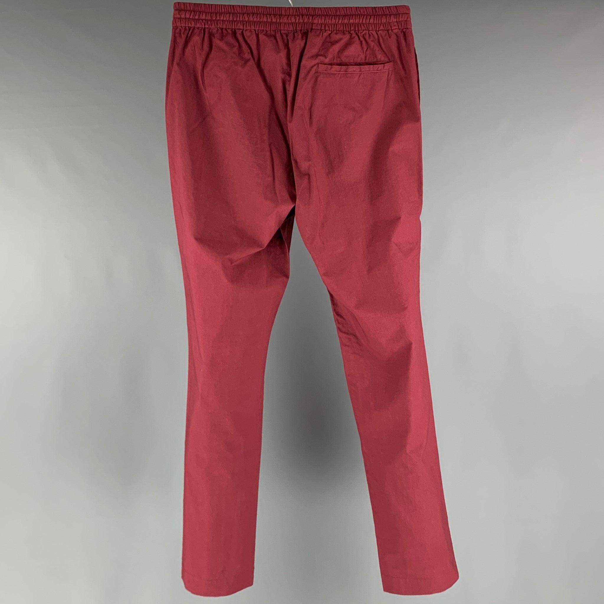 TOMAS MAIER casual pants comes in a burgundy cotton woven material featuring an elastic waistband, welt pockets, and a drawstring closure. Made in Italy.Excellent Pre- Owned Conditions. 

Marked:   M 

Measurements: 
  Waist: 28 inches Rise: 10