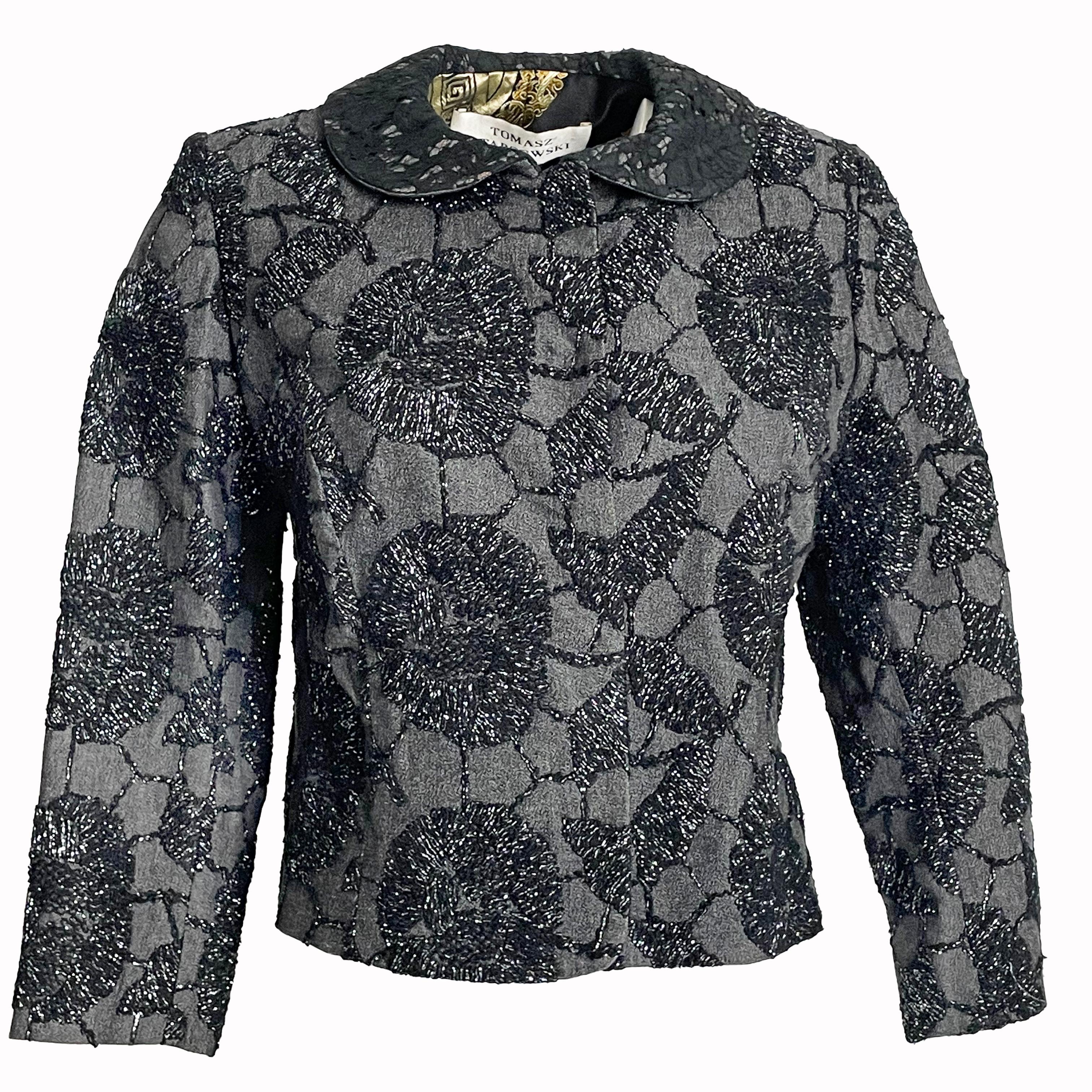 A fabulous and unique cropped jacket by UK designer Tomasz Starzewski, who designed for the late Diana, Princess of Wales amongst other members of the Royal Family. 

The jacket exterior features intricate metallic-thread embroidered florals against