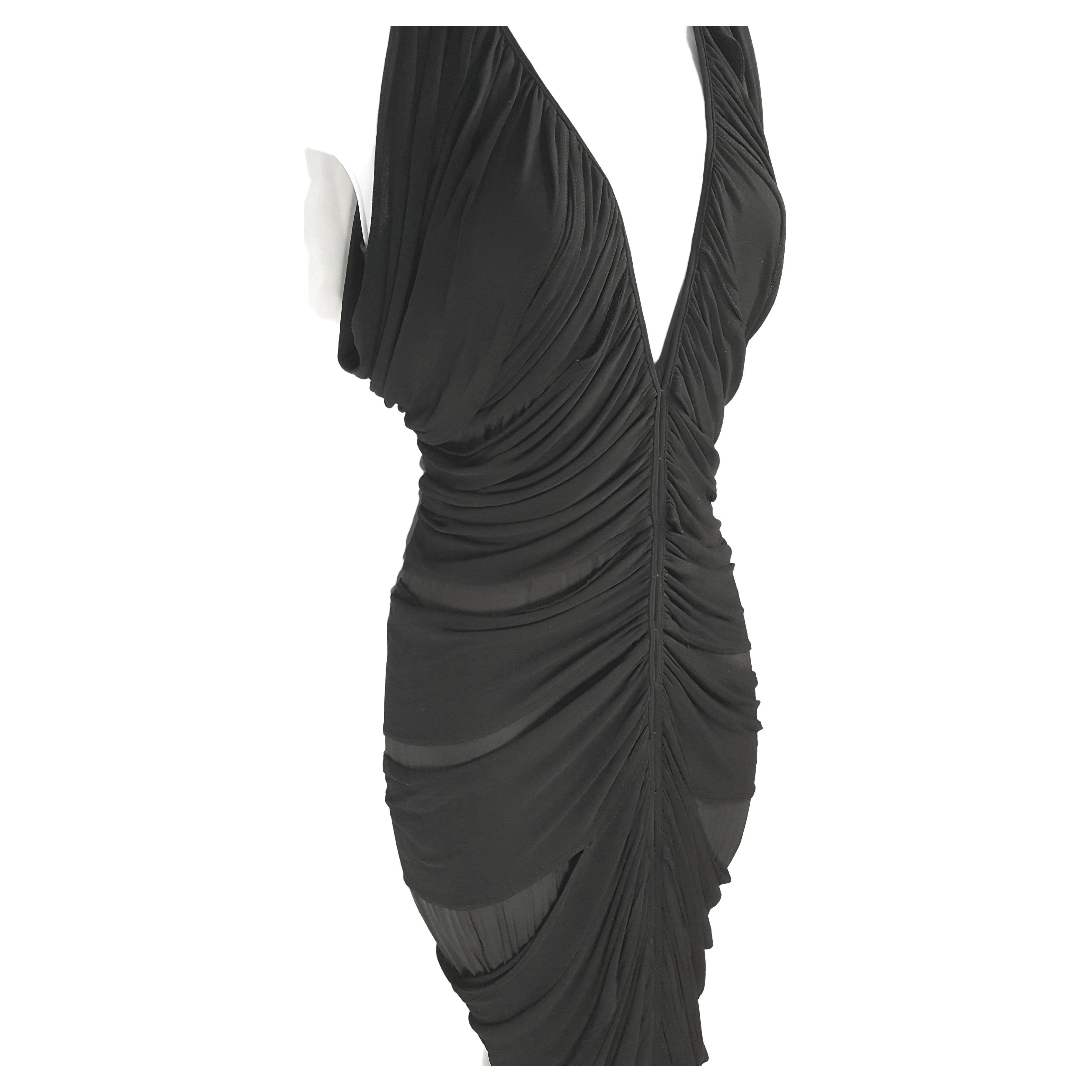 El estadounidense Tom Ford, para su primera colección para Yves Saint Laurent París/Rive Gauche, al tiempo que era director creativo de Gucci, diseñó este vestido de noche formal negro Primavera/Verano 2001, con un escote en V pronunciado y costuras