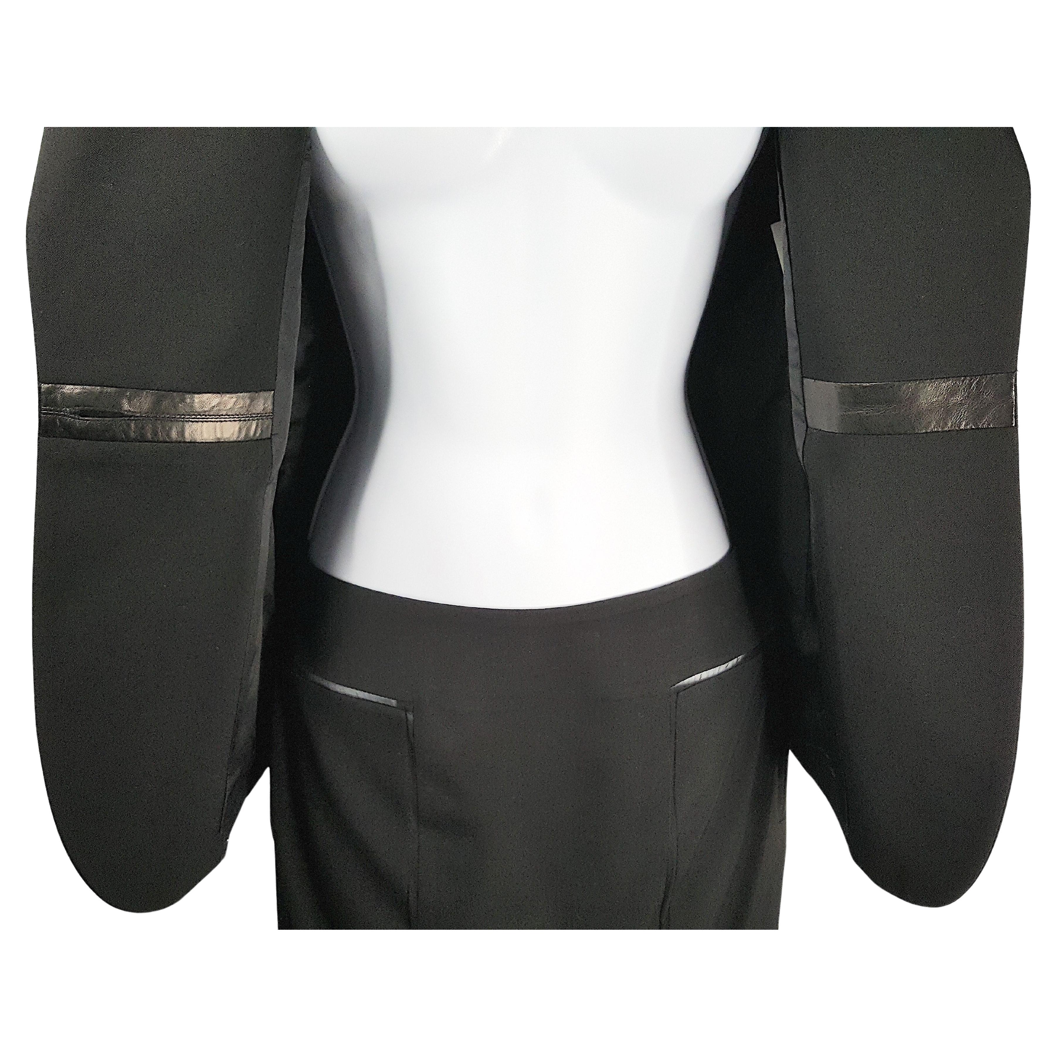 En su primera colección para Yves Saint Laurent Rive Gauche para la Primavera/Verano de 2001, el estadounidense Tom Ford estrenó en la pasarela de París este traje de noche de lana virgen negra estilo esmoquin que presenta unos exclusivos cortes en