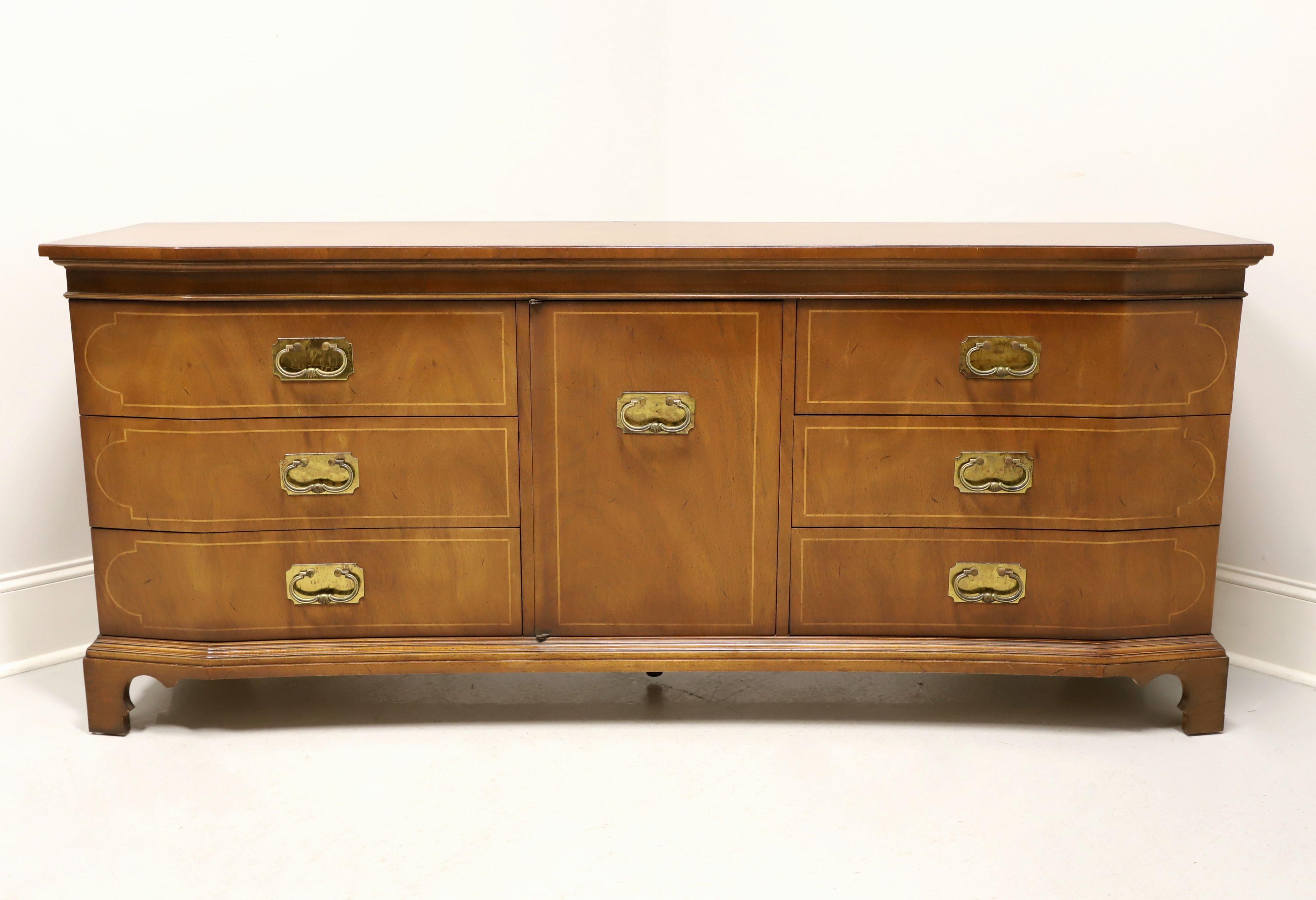 An Asian inspired triple dresser by Tomlinson Furniture. Walnut with a slightly distressed finish, brass hardware, slight serpentine front, string inlays to door & drawer fronts and bracket feet. Features nine drawers of dovetail construction, with