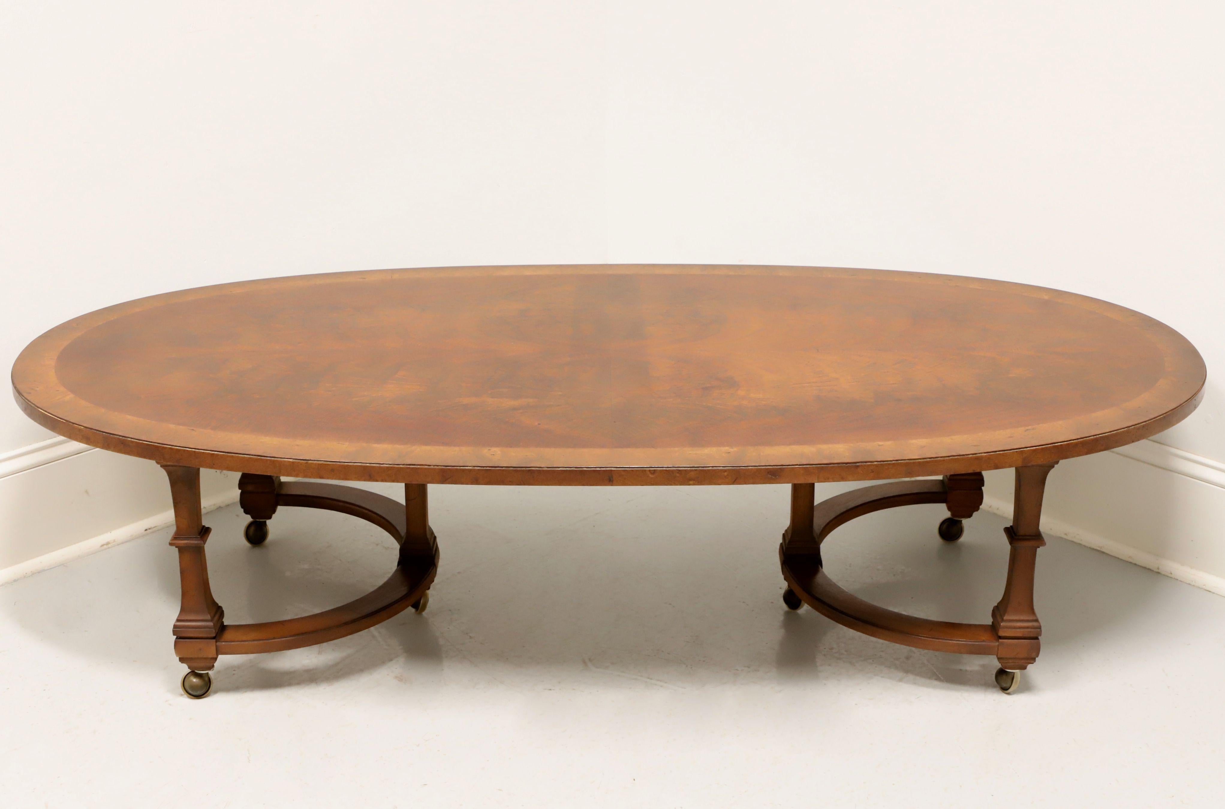 A Neoclassical style oval coffee table by Tomlinson Furniture. Mahogany with their Nutmeg finish, flame mahogany top with burlwood banding, three column like legs affixed to 