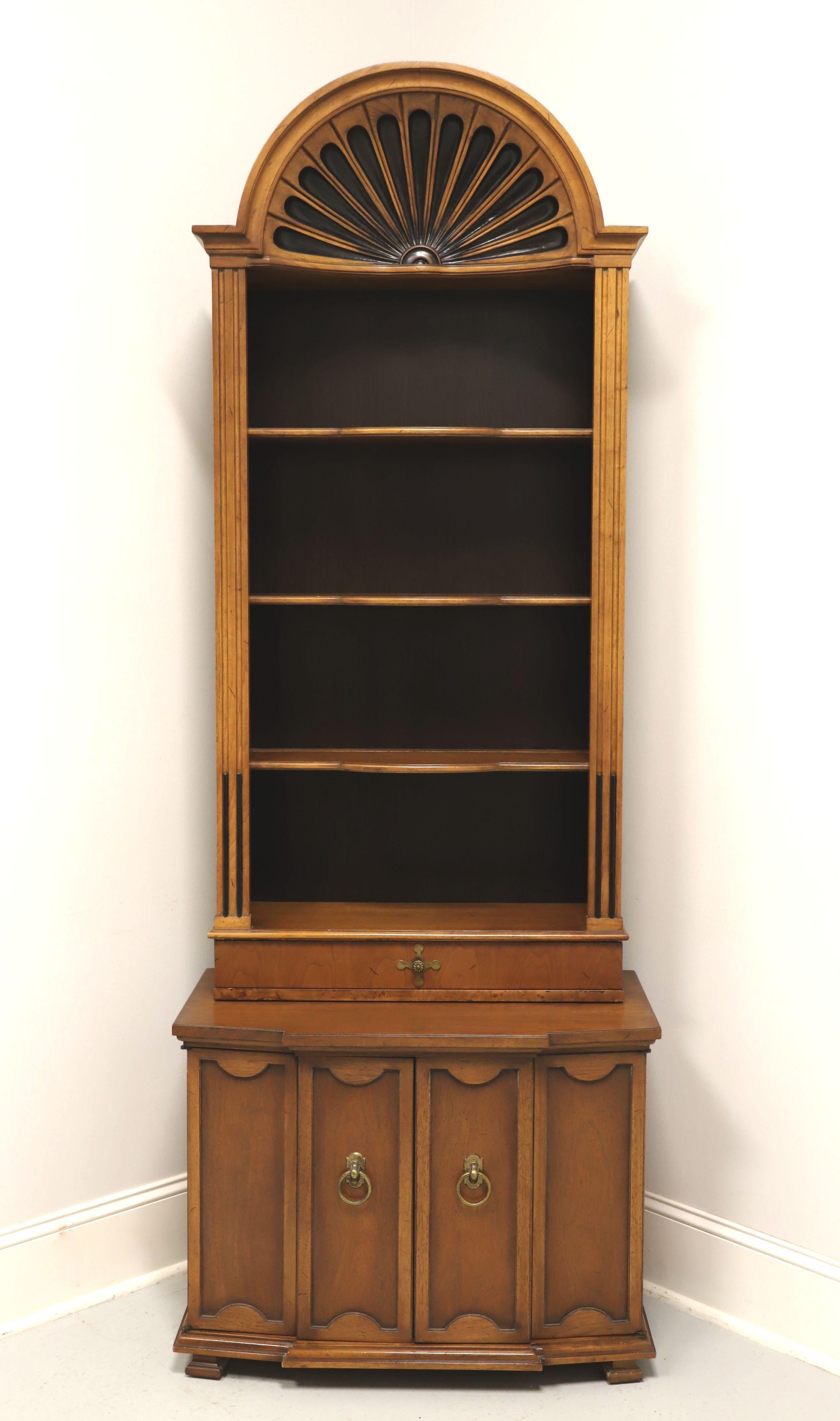 A Neoclassical style console cabinet with arched bookcase top by Tomlinson Furniture. Walnut with their Tokay finish, slight distressing and brass hardware. Features upper open bookcase with carved arch top, three fixed plate grooved wood shelves