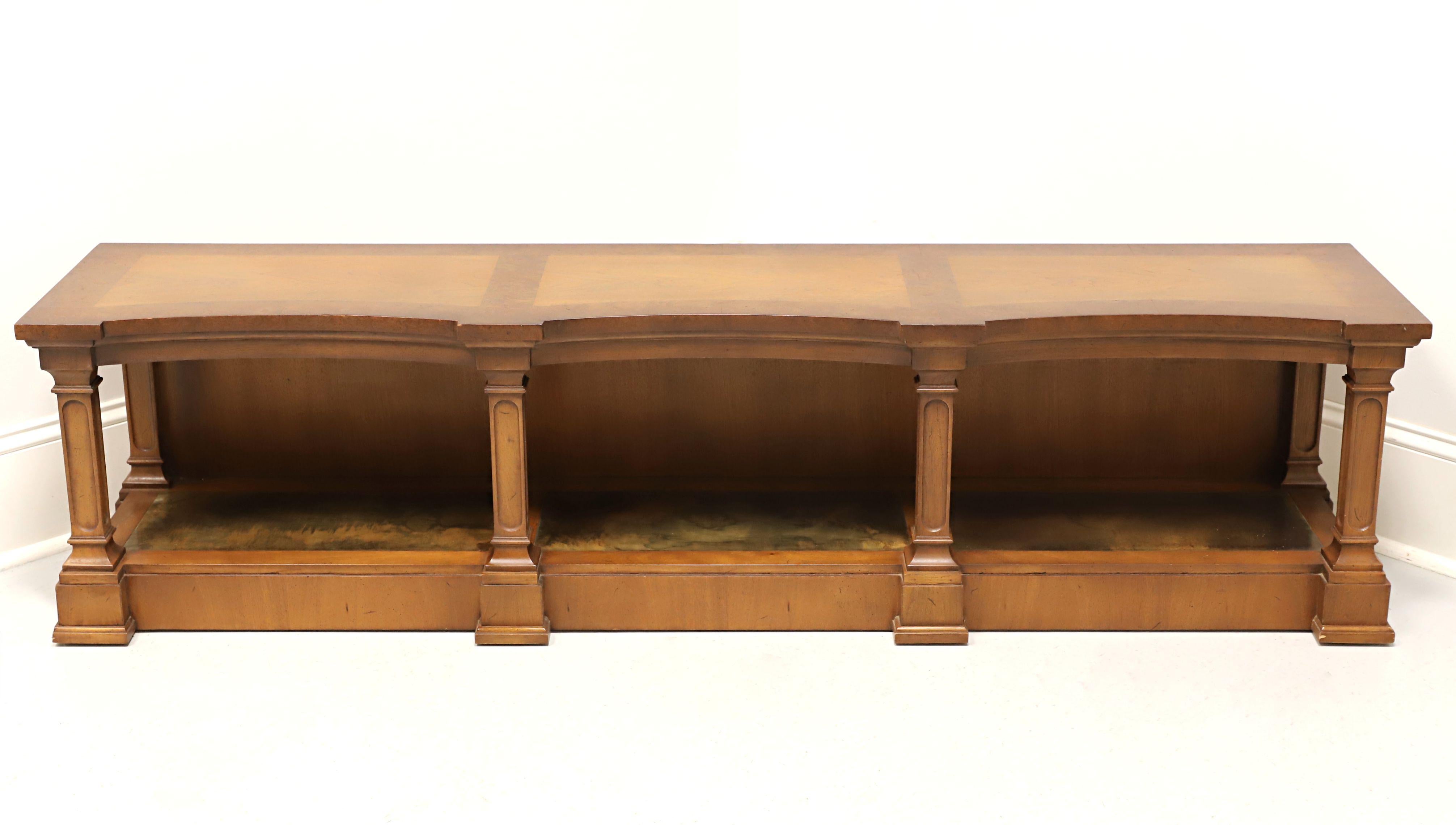 A Neoclassical style low console table, or alternatively a media stand, by Tomlinson Furniture. Walnut with slight distressing, banded burlwood to top, serpentine shaped, six column like supports, decoratively patinated brass to undertier shelf with