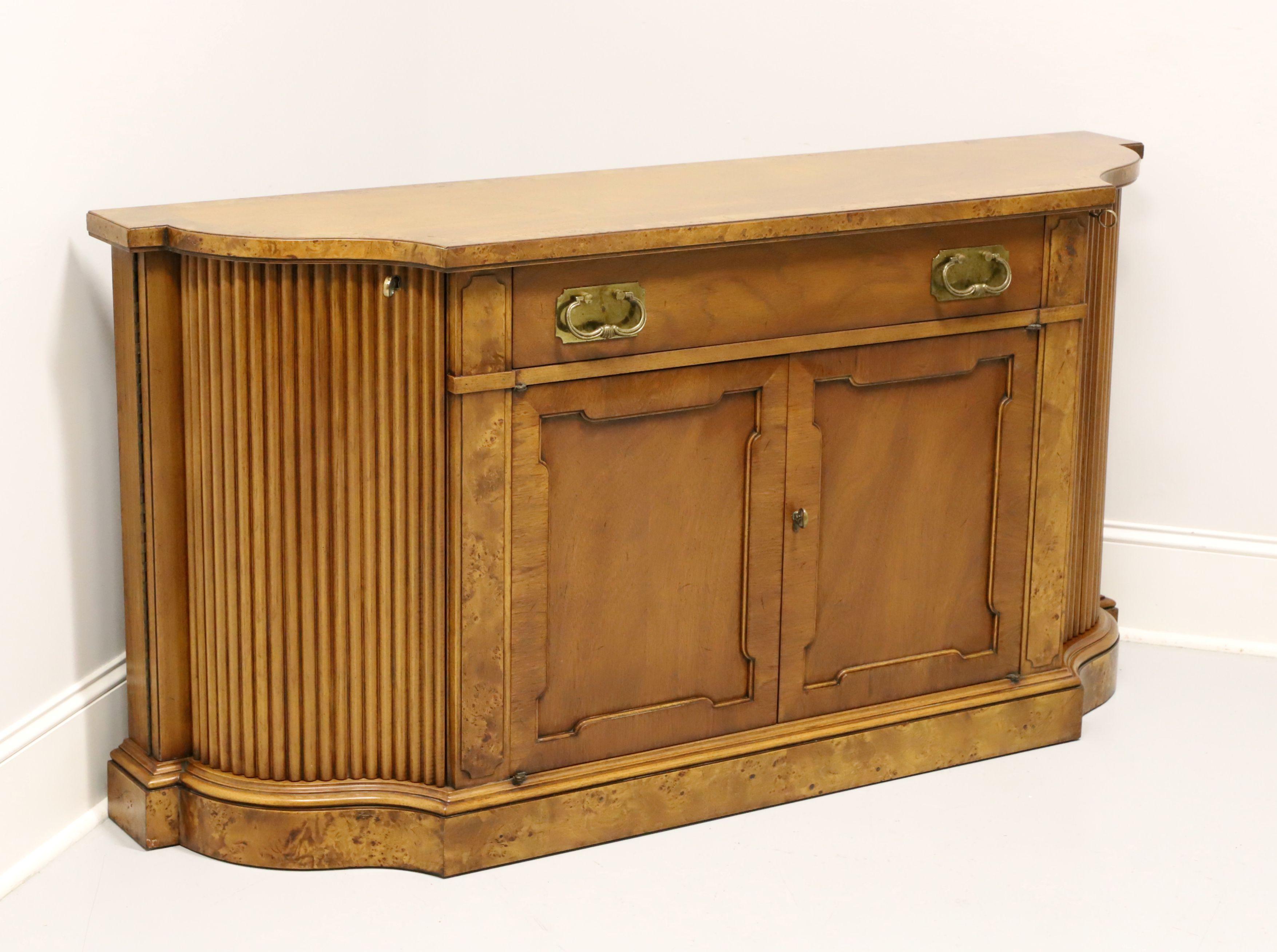 A Neoclassical style buffet server by Tomlinson Furniture. Mahogany with their Nutmeg finish, burlwood banding to top, serpentine front, brass hardware, burlwood accents flanking doors and to the base. Features one center drawer of dovetail